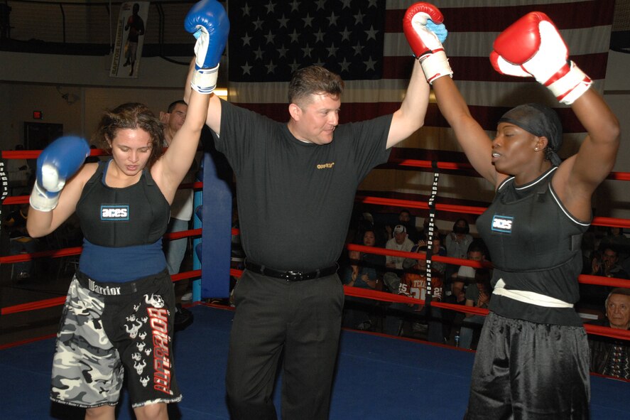 Airman 1st Class Krystal Macatol, 49th Maintenance Squadron, and Staff Sgt. Genese Williams, 49th Materiel Maintenance Support Squadron, raise their hands after a boxing match March 7 at Holloman Air Force Base, N.M. Though both gave an incredible performances, Sergeant Williams won the fight by decision. (U.S. Air Force photo/Airman 1st Class Jamal D. Sutter)