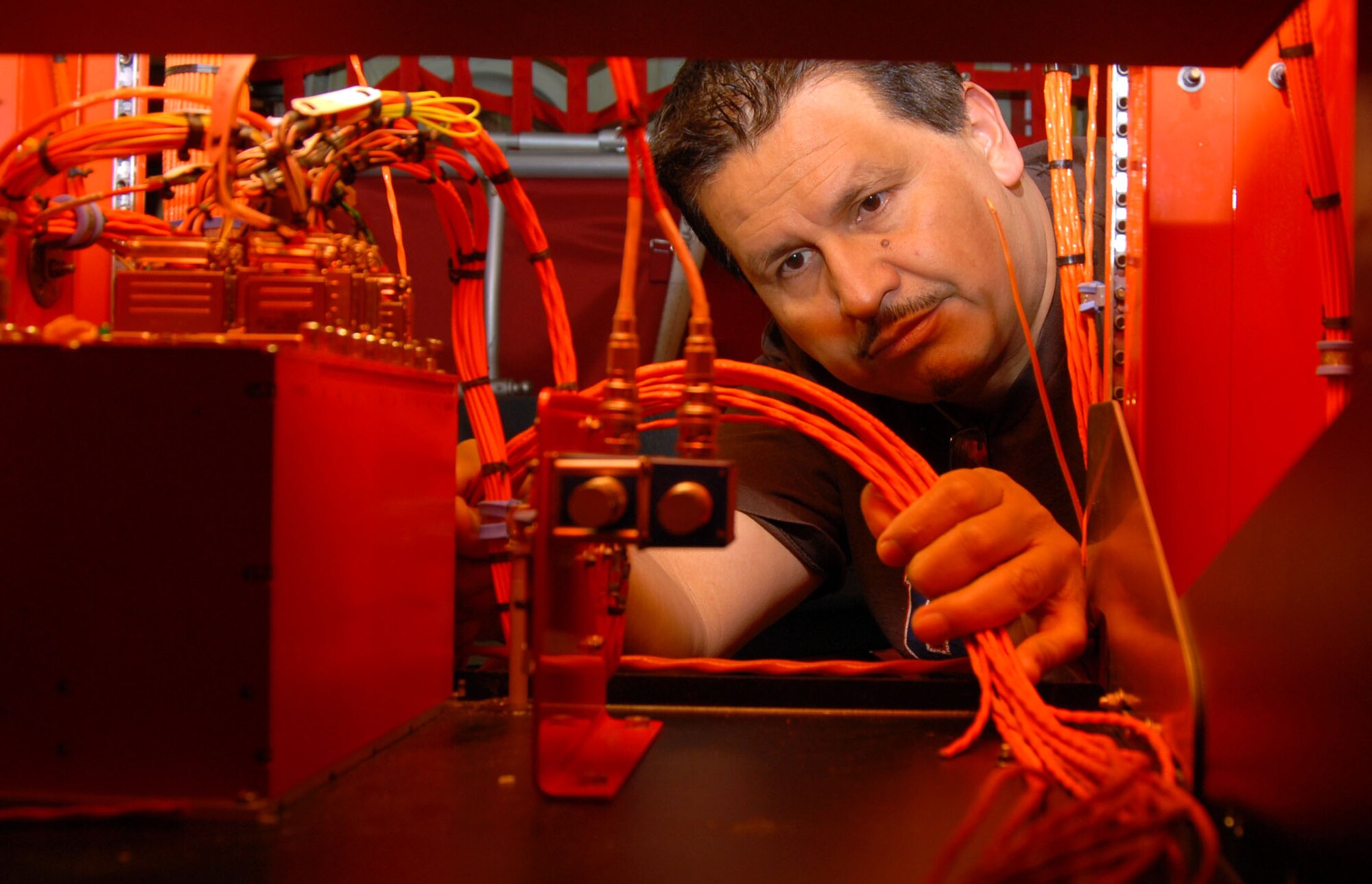 Selwyn Herrera, an electromechanical technician, installs wires through the C-130H Hercules' electromagnetic rack here March 5. The 418th Flight Test Squadron replaced the four-bladed propellers with the new eight-bladed NP-2000 propellers in support of the New York Air National Guard’s Operation Deep Freeze mission in Antarctica. (Air Force photo by Senior Airman Julius Delos Reyes)