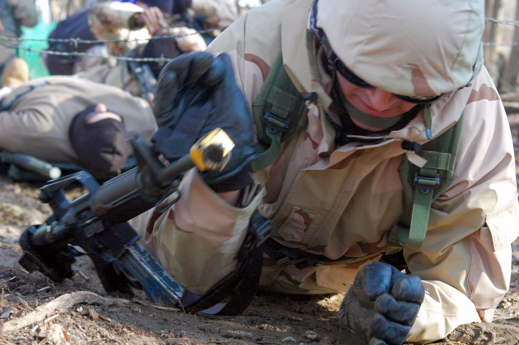 Students in the Air Force Expeditionary Center's Air Advisor Course 08-1 crawl under barbed wire as part of their training in the combat first aid obstacle course during training Feb. 29 on a range on Fort Dix, N.J. Taught by Expeditionary Operations School officials, Air Force Expeditionary Center's Air Advisor Course 08-1 prepares Airmen deploying to Afghanistan and Iraq who will in turn be training military forces in those countries. (U.S. Air Force photo/Tech. Sgt. Scott T. Sturkol) 
