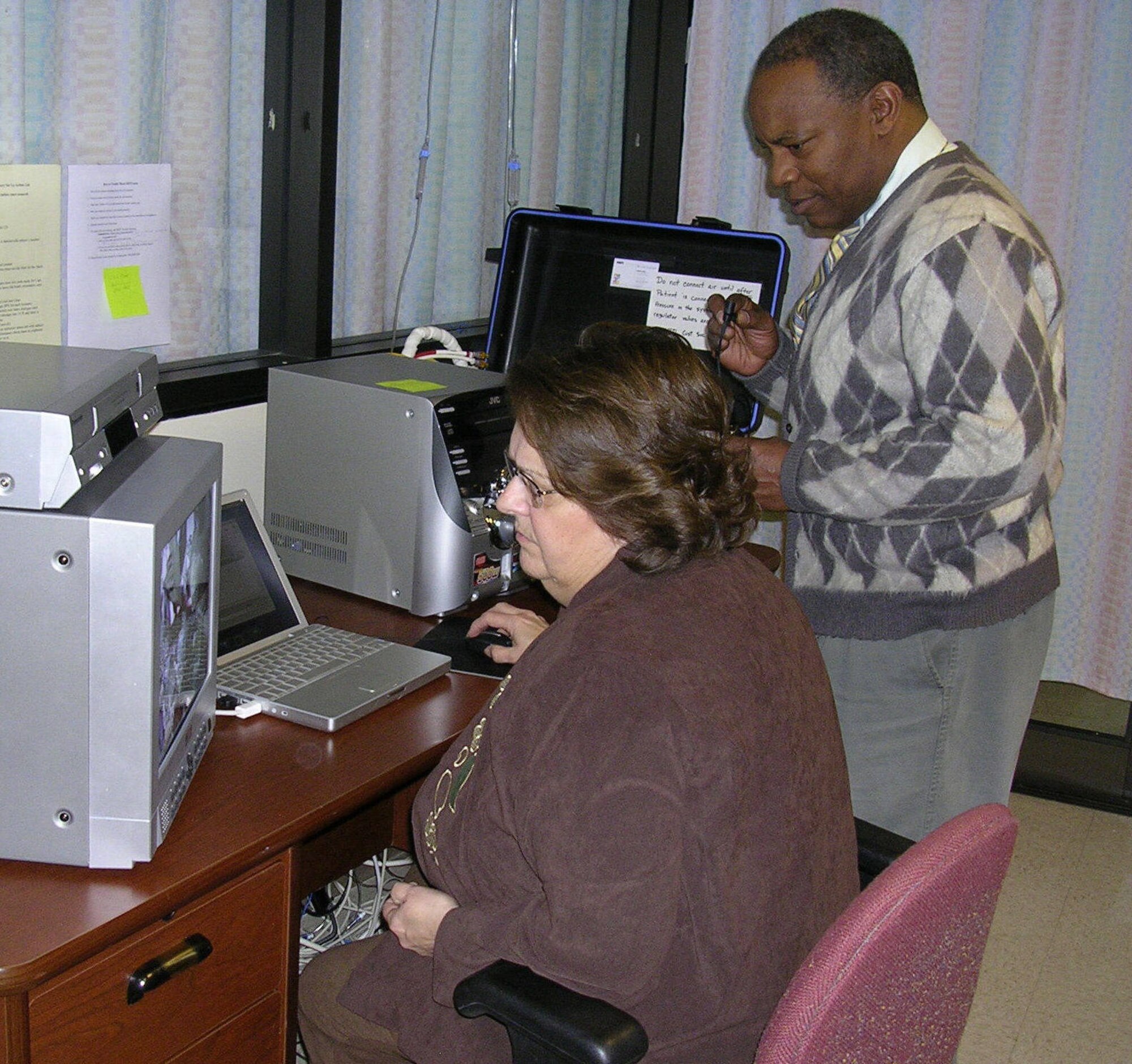 Norma Kirkpatrick, associate investigator, sits at the controls that bring to life Meti-man, a human patient simulator that trains nurses in critical thinking skills needed to manage trauma patients effectively in high stress situations. Jerome Ray, associate investigator, is the voice of Meti-man.(Air Force photos by Mike Frangipane)


