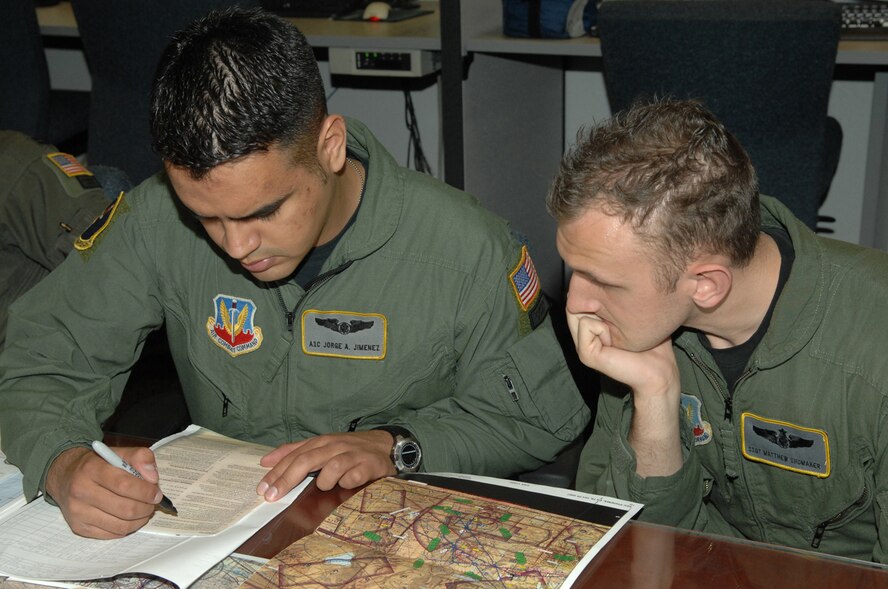 Airman 1st Class Jorge Jimenez, left, and Staff Sgt. Matthew Shumaker, 79th Rescue Squadron, review mission plans at the 79th RQS here Feb. 27. (U.S. Air Force photo by Airman 1st Class Noah R. Johnson)