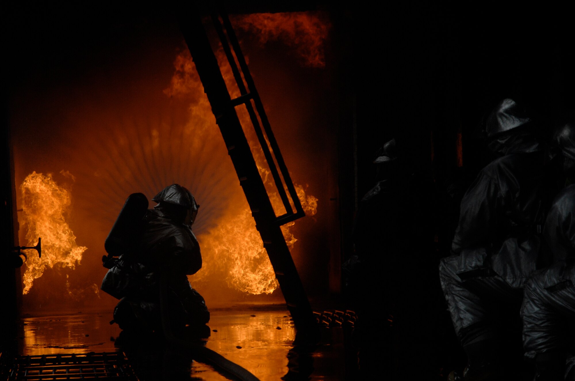 48th Civil Engineer Squadron firefighters attack a simulated cargo fire inside an aircraft fire trainer, March 8 at RAF Mildenhall, England. Firefighters must train constantly to stay proficient in their aircraft rescue and firefighting skills. (U.S. Air Force photo by Airman Perry Aston)


