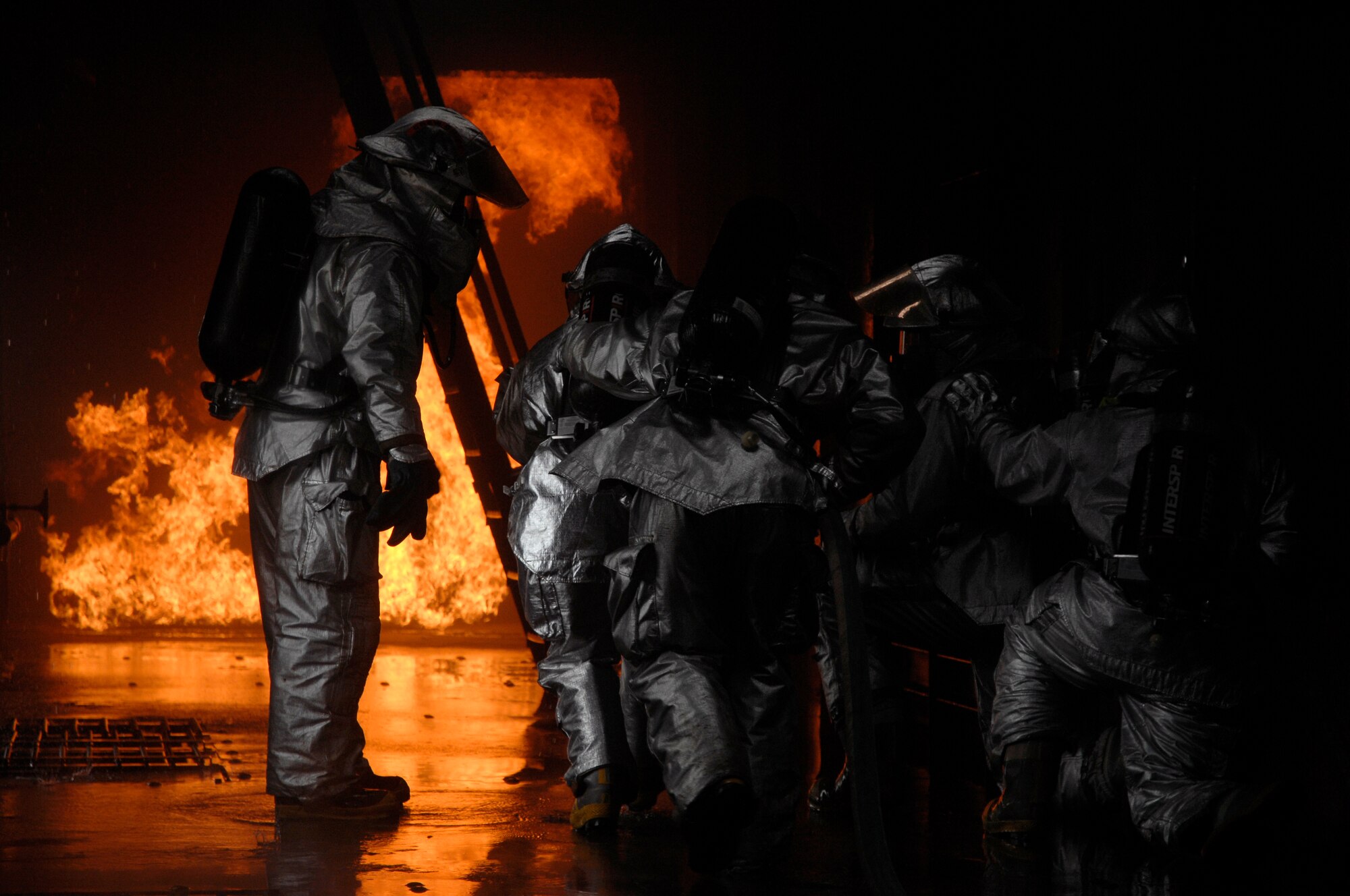 Master Sgt. Walter Wright (left), 48th Civil Engineer Squadron firefighter, instructs firefighters to advance towards the simulated cargo fire, March 8 at RAF Mildenhall, England. Sergeant Wright was the training instructor for all internal fires inside the aircraft fire trainer. (U.S. Air Force photo by Airman Perry Aston) 

