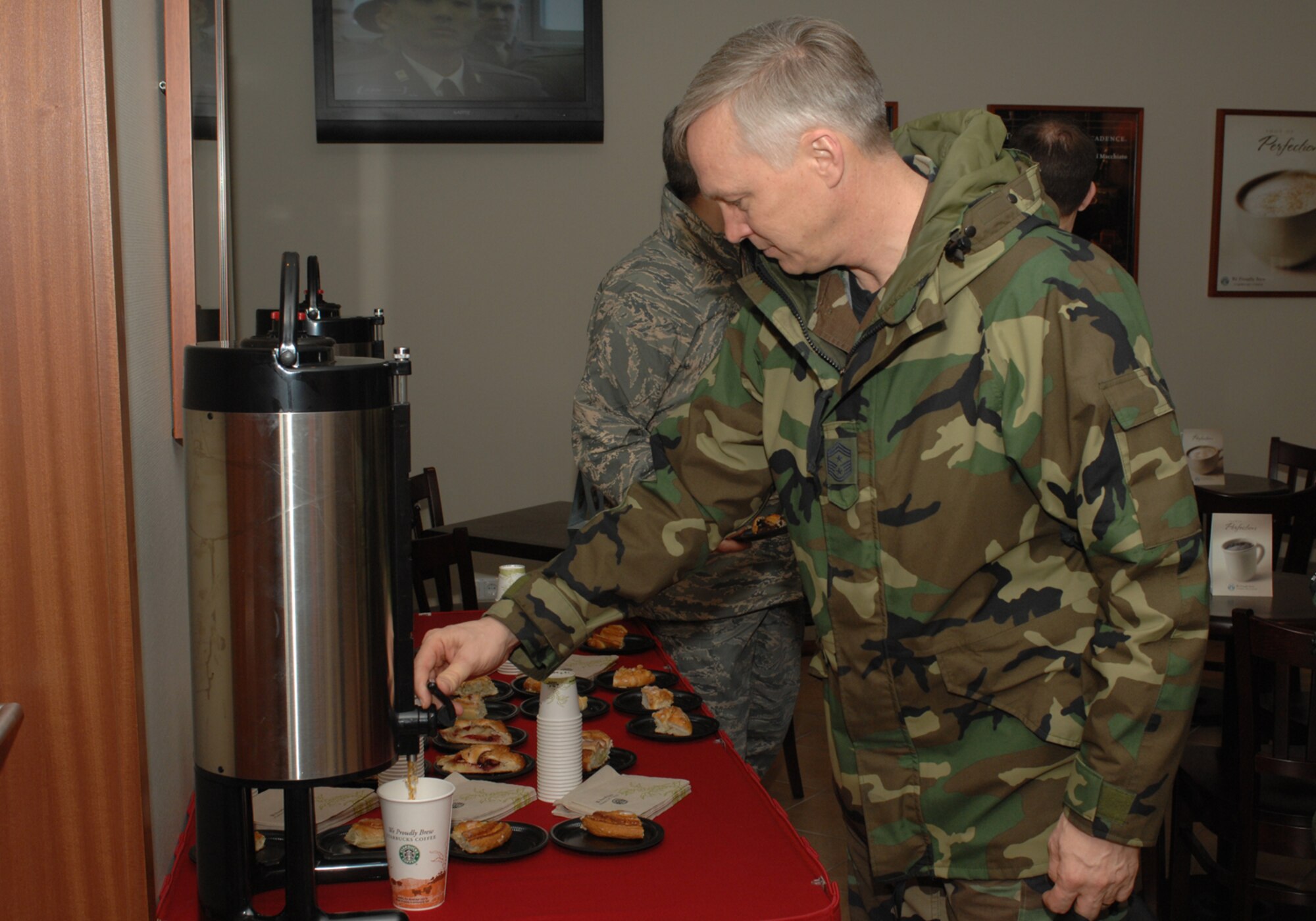 Spangdahlem Air Base, Germany- Chief Master Sgt Vance Clarke, 52nd Fighter Wing Command Chief, pours coffee at the grand opening of Kuhl Beans, a coffee shop intended for the airmen on base to enjoy various types of pastries and coffees.  US Air Force photo by SSgt Kristen Ruleau.

