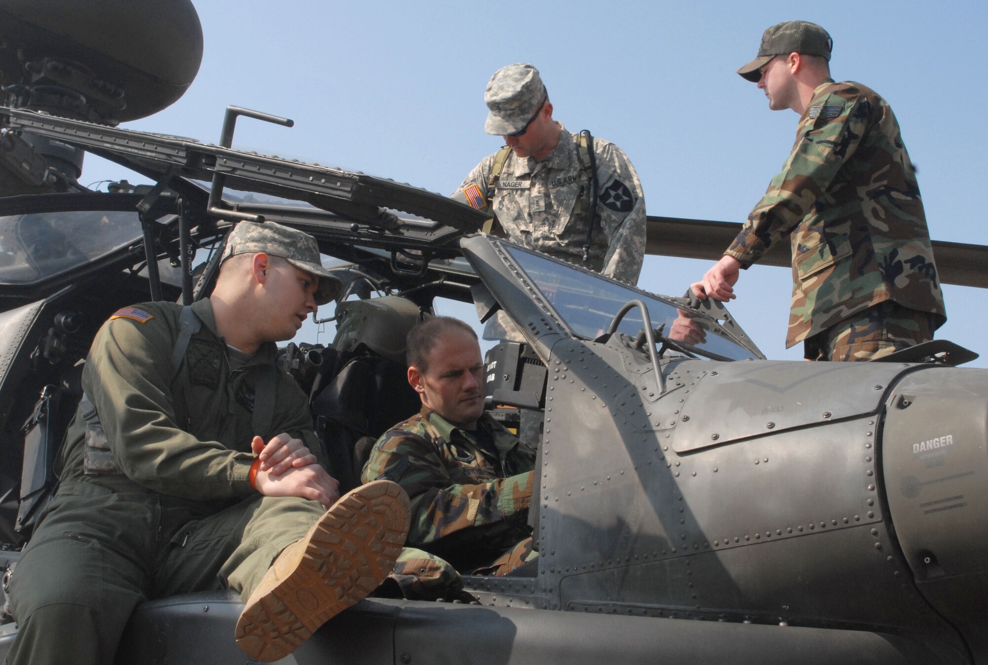 KUNSAN AIR BASE, Republic of Korea -- Chief Warrant Officer 2nd Class Thomas Weekley (front), a pilot with Charlie Company, 4-2 Attack Battalion, 2nd Combat Aviation Brigade from Camp Humphreys discusses the AH-64D Apache helicopter with Senior Airman Richard Addis, an Electronic Warfare Craftsman with the 8th Maintenance Squadron while Chief Warrant Officer 3rd Class Pat Nager (back), a standardization instructor pilot with Charlie Company, 4-2 Attack Battalion, 2nd Combat Aviation Brigade answers Senior Airman Joshua McGinnis', a firefighter with the 8th Civil Engineer Squadron, questions about fire rescue operations during a static display of the aircraft here Mar. 10.  The event was designed to inform Airmen about the aircraft and the Army's current mission here.  (U.S. Air Force photo/Staff Sgt. Darcie Ibidapo)