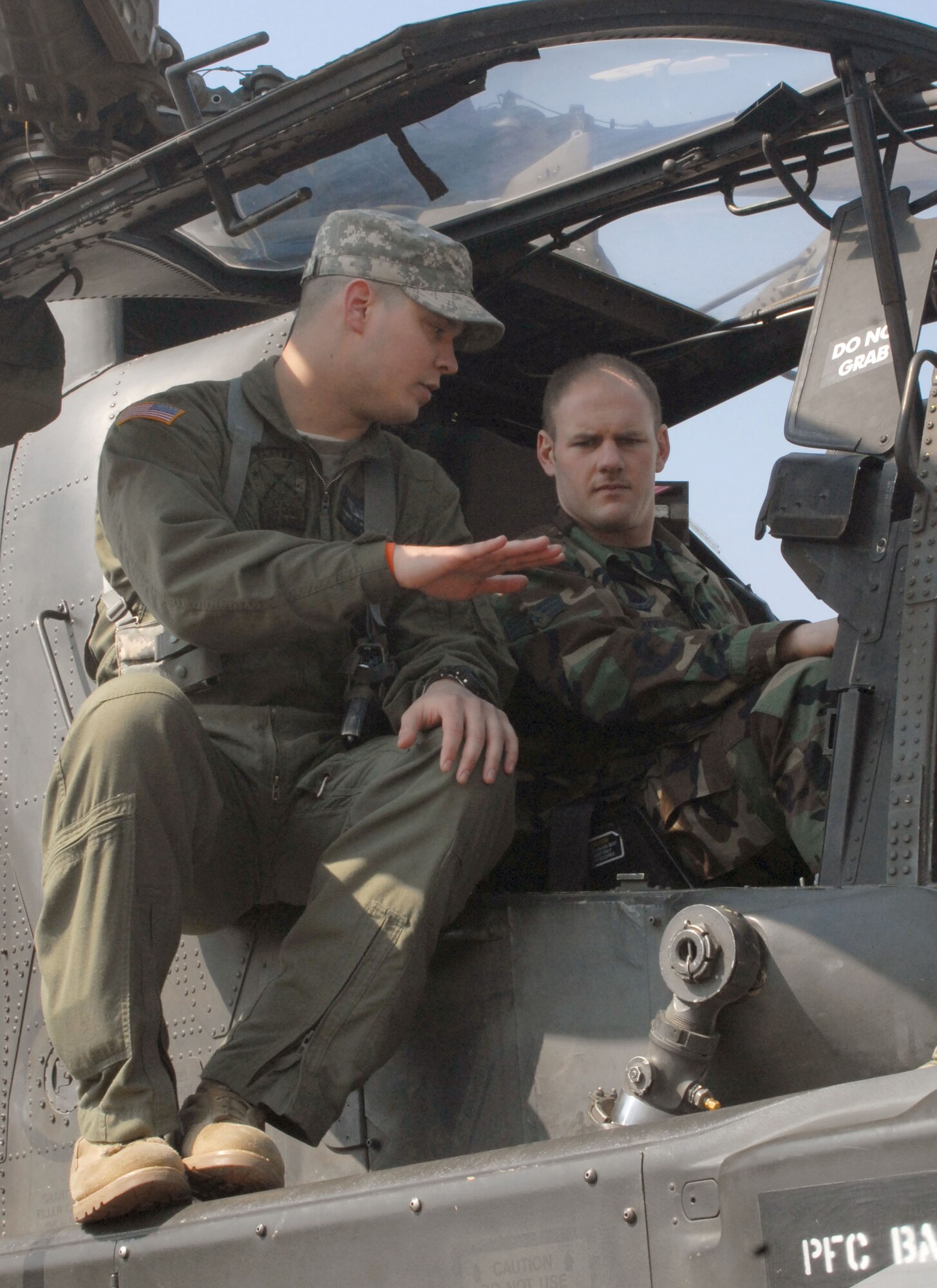 KUNSAN AIR BASE, Republic of Korea -- Chief Warrant Officer 2nd Class Thomas Weekley, a pilot with Charlie Company, 4-2 Attack Battalion, 2nd Combat Aviation Brigade from Camp Humphreys discusses the AH-64D Apache helicopter with Senior Airman Richard Addis, an Electronic Warfare Craftsman with the 8th Maintenance Squadron during a static display of the aircraft here Mar. 10.  The event was designed to inform Airmen about the aircraft and the Army's current mission here.  (U.S. Air Force photo/Staff Sgt. Darcie Ibidapo)