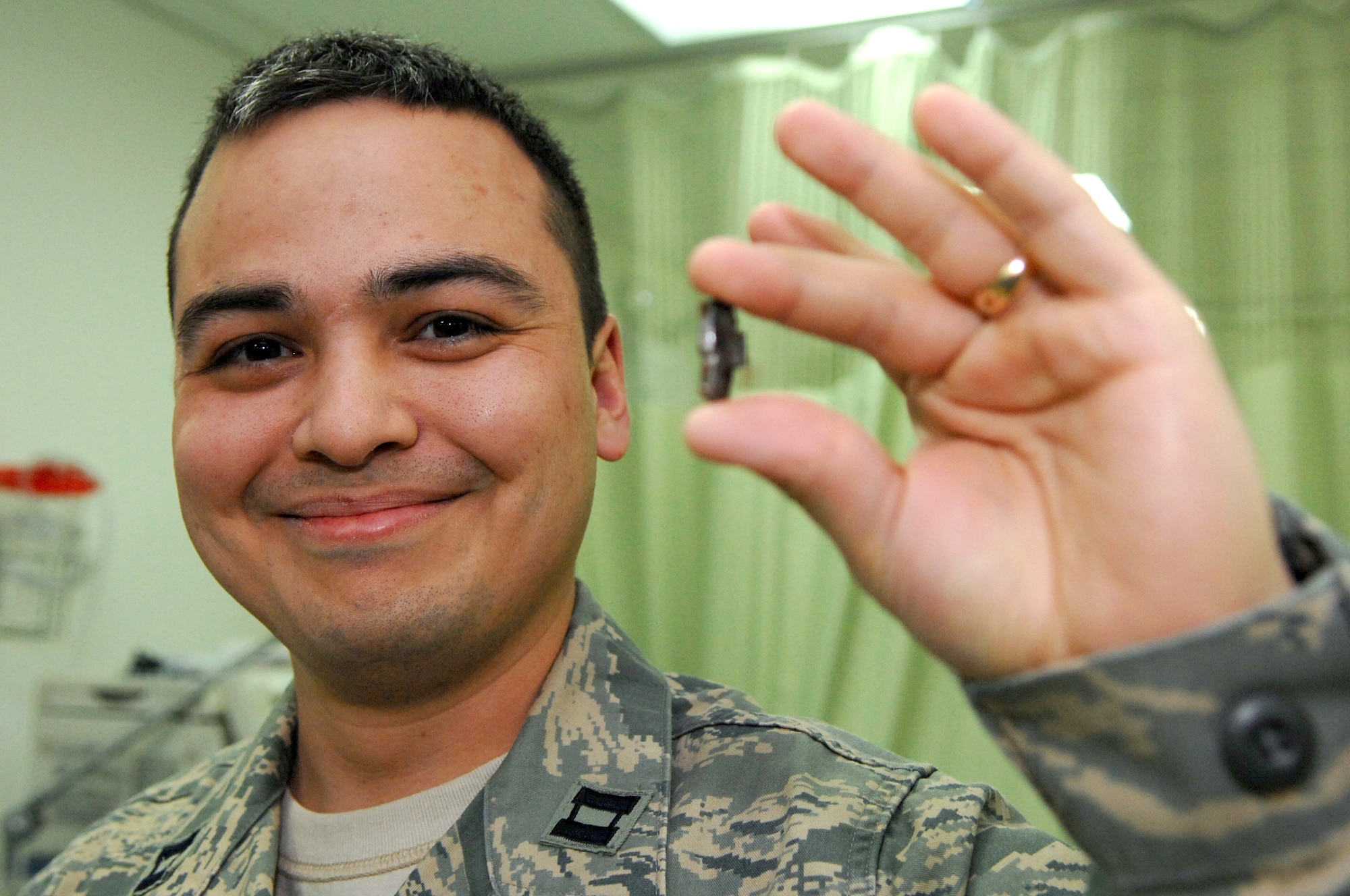 BALAD AIR BASE, Iraq -- Capt. Adrian Barcus, 332nd Expeditionary Medical Operations Squadron intensive care unit staff physician, shows a piece of shrapnel that wounded him here, March 7. Captain Barcus is deployed from Scott Air Force Base, Ill. (U.S. Air Force photo/ Senior Airman Julianne Showalter)