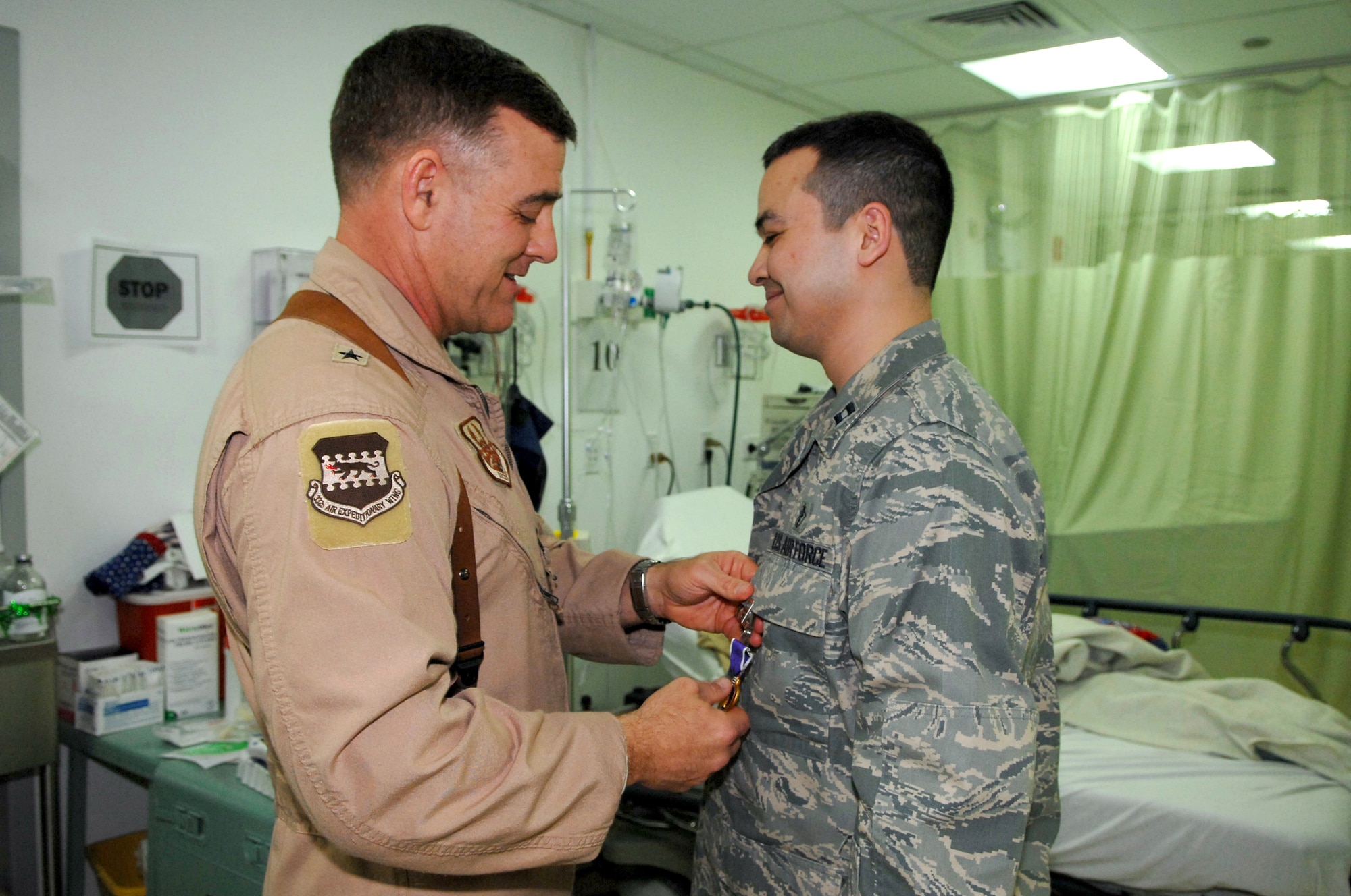 BALAD AIR BASE, Iraq -- Brig. Gen. Burt Field, 332nd Air Expeditionary Wing commander, pins a Purple Heart onto Capt. Adrian Barcus, 332nd Expeditionary Medical Operations Squadron intensive care unit staff physician, for being wounded by shrapnel here, March 7. Captain Barcus is deployed from Scott Air Force Base, Ill. (U.S. Air Force photo/ Senior Airman Julianne Showalter)
