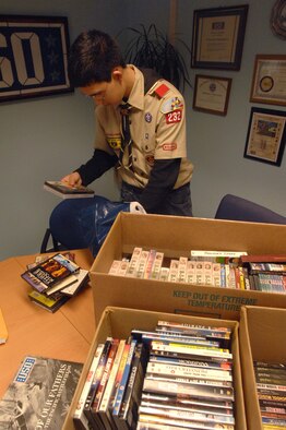 Eagle Scout Kevin Stewart organizes DVDs for his leadership service project at the United Service Organizations administration office on Pulaksi Barracks Feb. 29.  Kevin collected 330 DVDs to distribute to the Air Moblilty Command passenger terminal, to wounded Soldiers at the Contingency Aeromedical Staging Facility, and to the new USO opening at Landstuhl Regional Medical Center. Photo by Airman 1st Class Amber Bressler