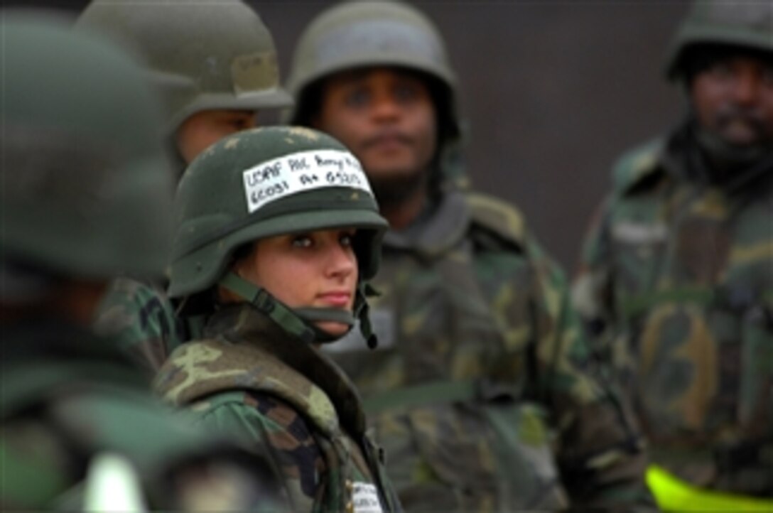 Airman 1st Class Amy Gisler, U.S. Air Force, and her fellow airmen wait for further instructions from their squad leader during a training exercise at Ramstein Air Base, Germany, on Feb. 26, 2008.  Gisler and airmen from the 31st Contracting Squadron out of Aviano Air Base, Italy, are taking part in deployment training exercise Silver Flag at Ramstein.  