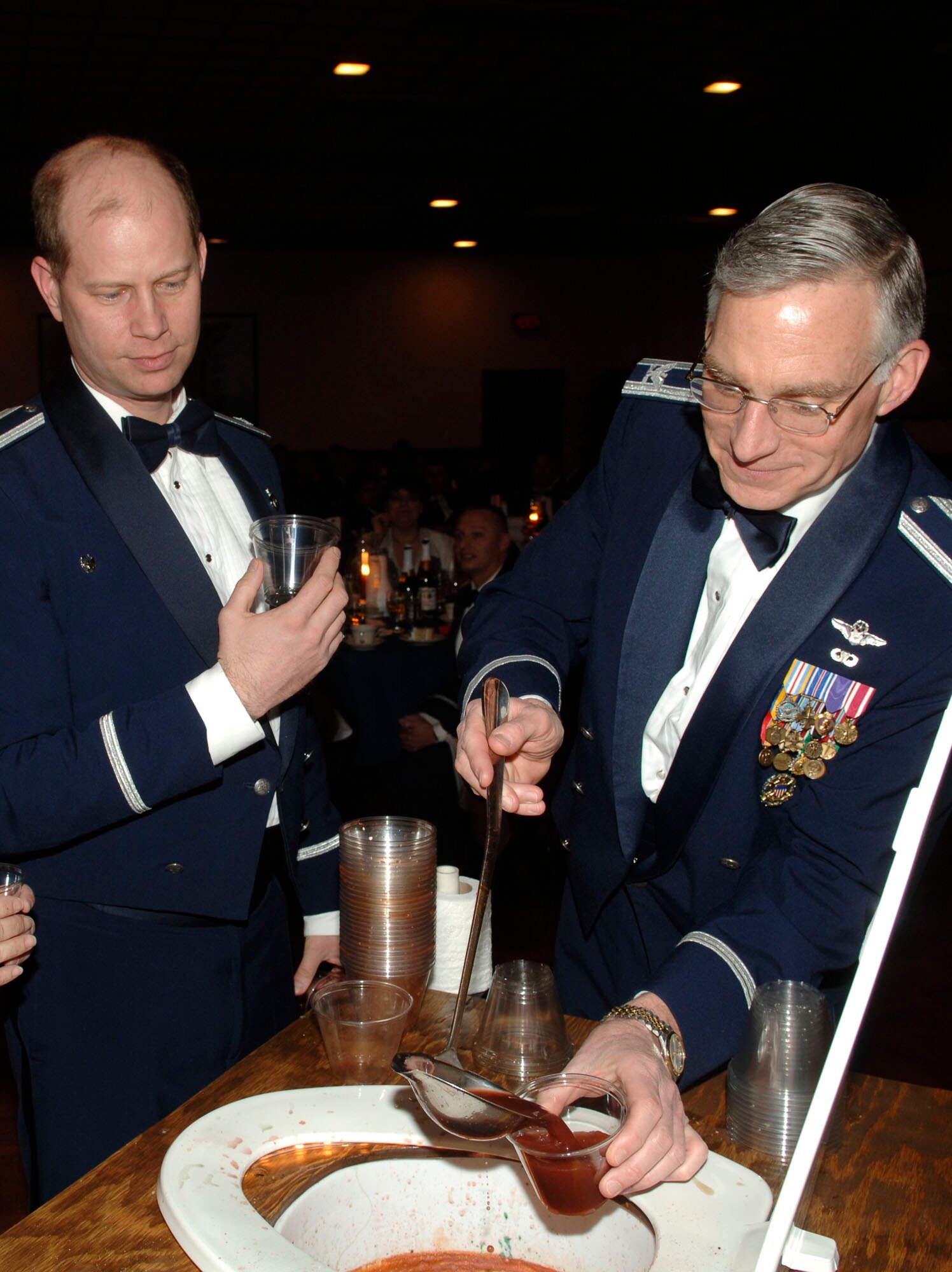 FAIRCHILD AIR FORCE BASE, Wash. – Lt. Col. John Foden, 92nd Mission Support Group vice commander, and Col. Thomas Griffith, dean of faculty and academic programs, National War College, ladle out cups of grog during the 92nd MSG dining out at Club Fairchild March 7. The dining out custom began in the 1930s with Gen. H. “Hap” Arnold’s “wing-dings”, enhancing the esprit-de-corps of military members and their guests. (U.S. Air Force photo/Senior Chad Watkins)