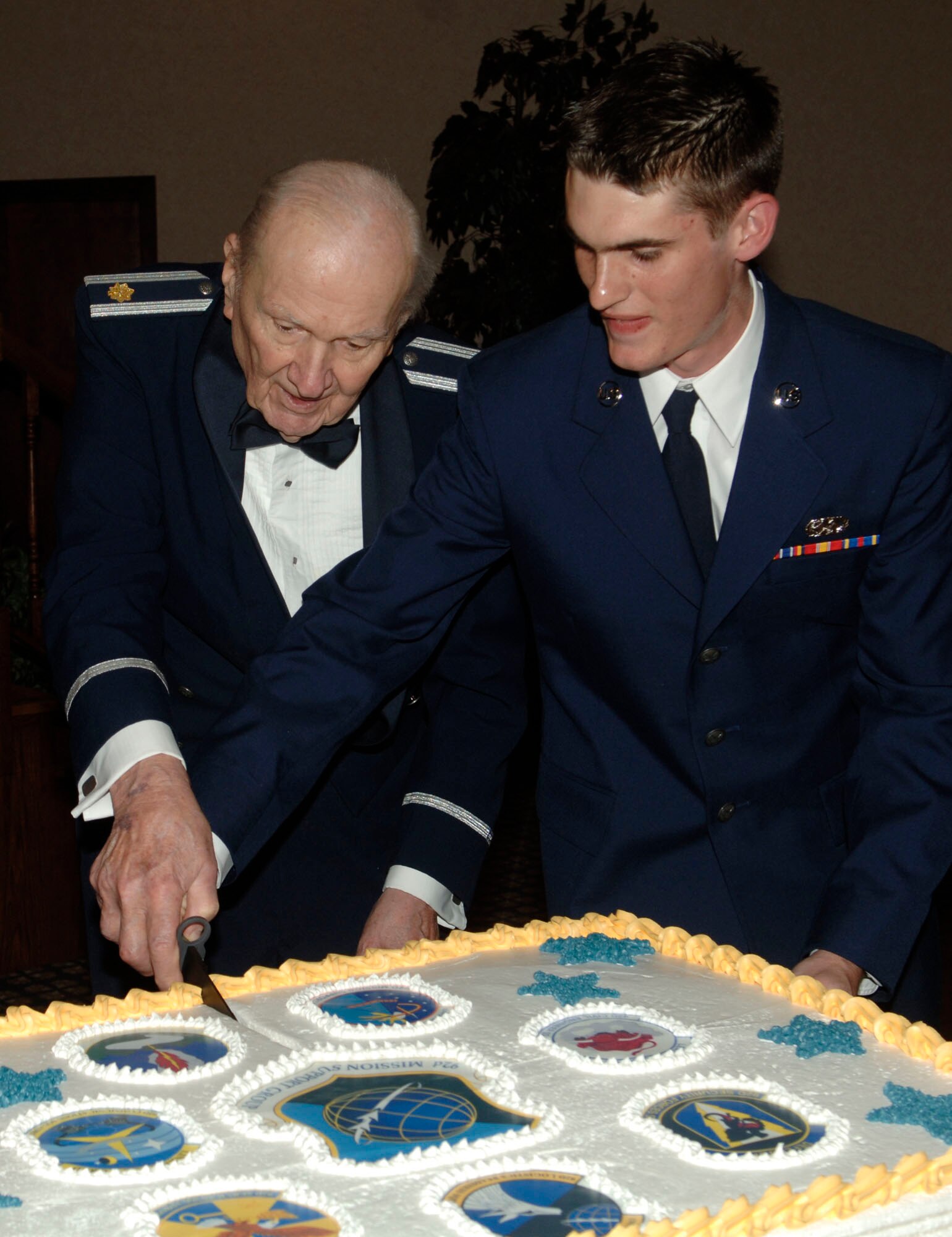 FAIRCHILD AIR FORCE BASE, Wash. –Retired Maj. Ed Majeski and Airman Joel Barrot, 92nd Logistics Readiness Squadron, cut the ceremonial cake during the 92nd Mission Support Group dining out at Club Fairchild March 7. The cake cutting is traditionally done by the oldest and youngest person in attendance. (U.S. Air Force photo/Senior Chad Watkins)