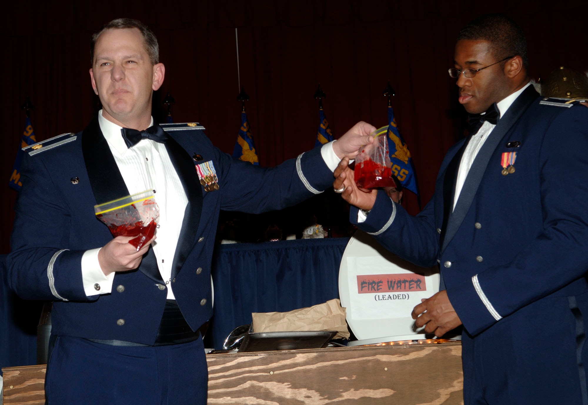 FAIRCHILD AIR FORCE BASE, Wash. – Maj. Fred Lacy and 2nd Lt. Chikaodi Akalaonu, 92 Contracting Squadron, prepare to put their squadron’s ingredient into the grog bowl during the 92nd Mission Support Group dining out at Club Fairchild March 7.  The ingredient symbolized the blood from paper cuts, while the other six squadrons added ingredients symbolic of their squadrons mission. (U.S. Air Force photo/Senior Chad Watkins)