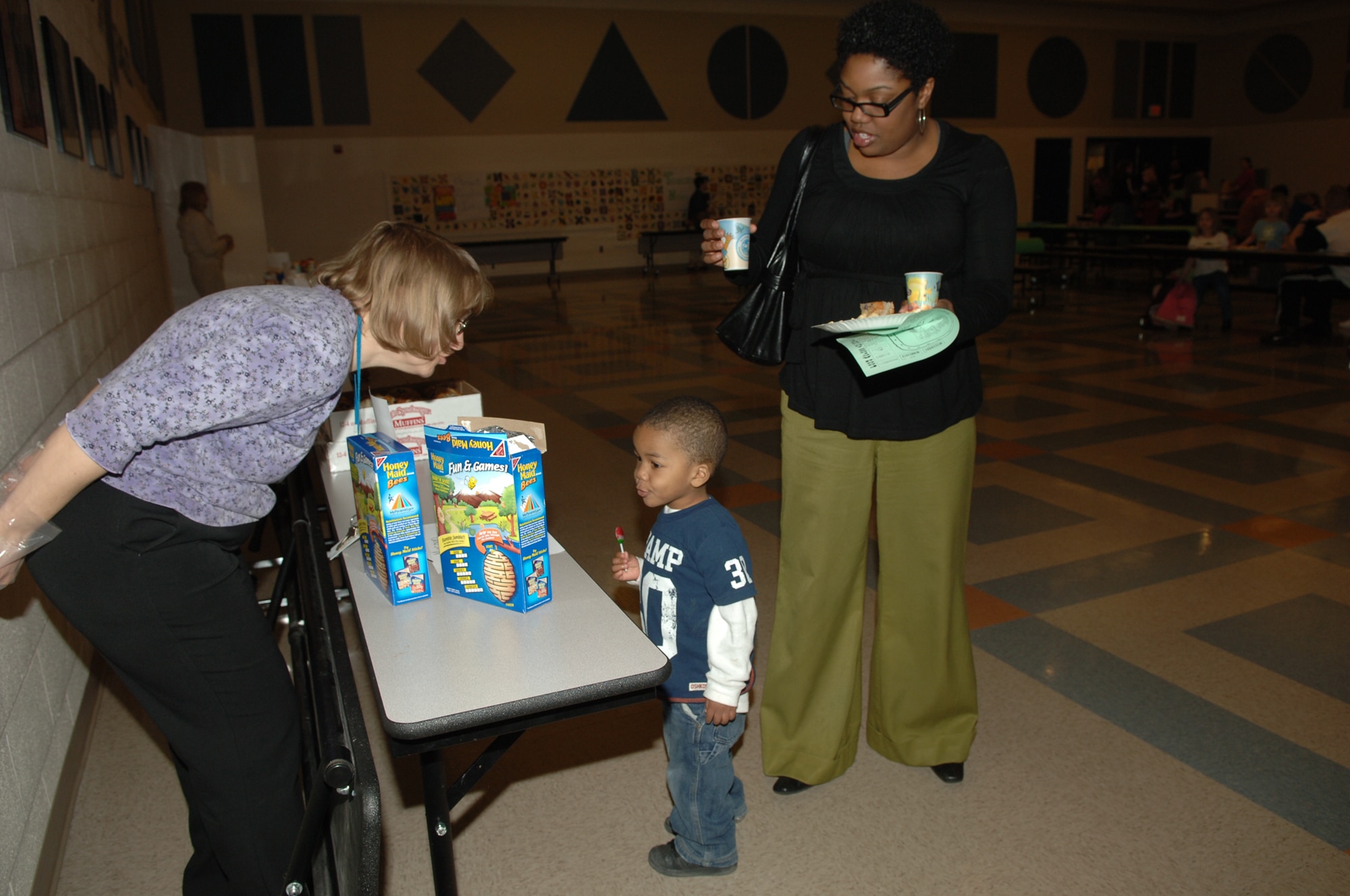 FAIRCHILD AIR FORCE BASE, Wash. – Javonika McCree watches as her son, Jayden, thanks a volunteer during Family Night at Michael Anderson Elementary March 6. Going through the line for snacks was like taking a trip across the country, getting orange juice from Florida and chips and salsa from Texas. (U.S. Air Force photo/Senior Airman Jocelyn Ford)