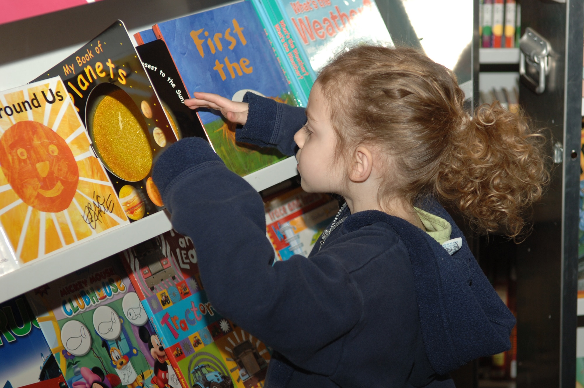 FAIRCHILD AIR FORCE BASE, Wash. – Anna Ryplewski, 3-year-old daughter of Tech. Sgt. Matthew Ryplewski, looks through several books before finding the one she wants to take home from the Book Fair held at Michael Anderson Elementary March 6. Fifty percent of all sales from the Book Fair go directly back to the school library. (U.S. Air Force photo/Senior Airman Jocelyn Ford)