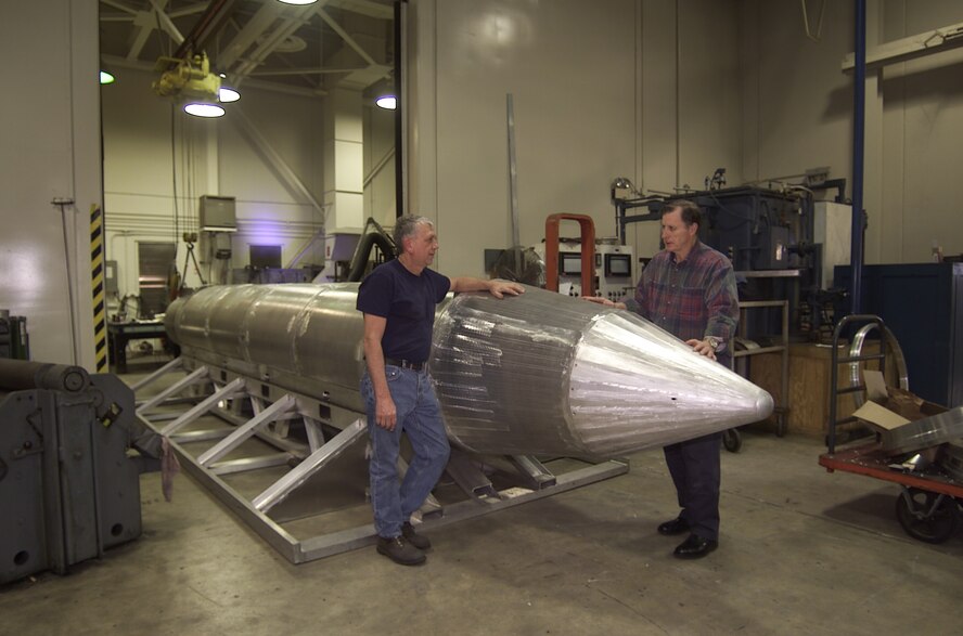 Al Weimorts (left), the creator of the GBU-43/B Massive Ordnance Air Blast bomb, and Joseph Fellenz, lead model maker, look over the prototype before it was painted and tested. (Courtesy photo)