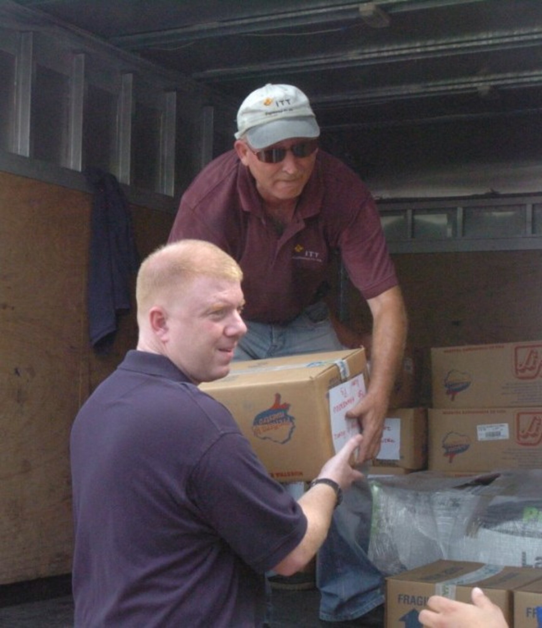 Edward Sanders, an ITT employee, hands Commander Derek Lannuier a box of intravenous bags that were donated to the Napoleon Billa hospital in Chone, Ecuador Friday to help them resupply after some of the worst flooding in two decades.  CDR Lannuier, the Humanitarian Assistance Program Coordinator for the U.S. Military Group in Quito oversaw this project and ensured that the DeMinimus Projuct funding was approved.  