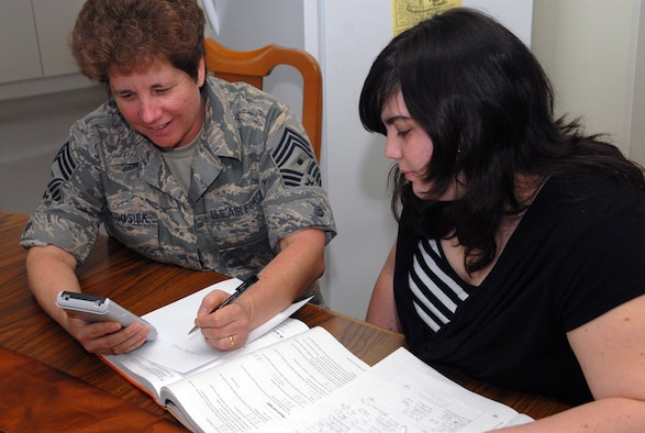 Chief Master Sgt. Cherry Wielgosiek, 18th Equipment Maintenance Squadron first sergeant helps her daughter, Tyler, with her math homework.  Simple things like this must often be put on hold during exercises and contigencies, such as this week's Operational Readiness Inspection.  (U.S. Air Force Photo/Staff Sgt. Christopher Marasky)