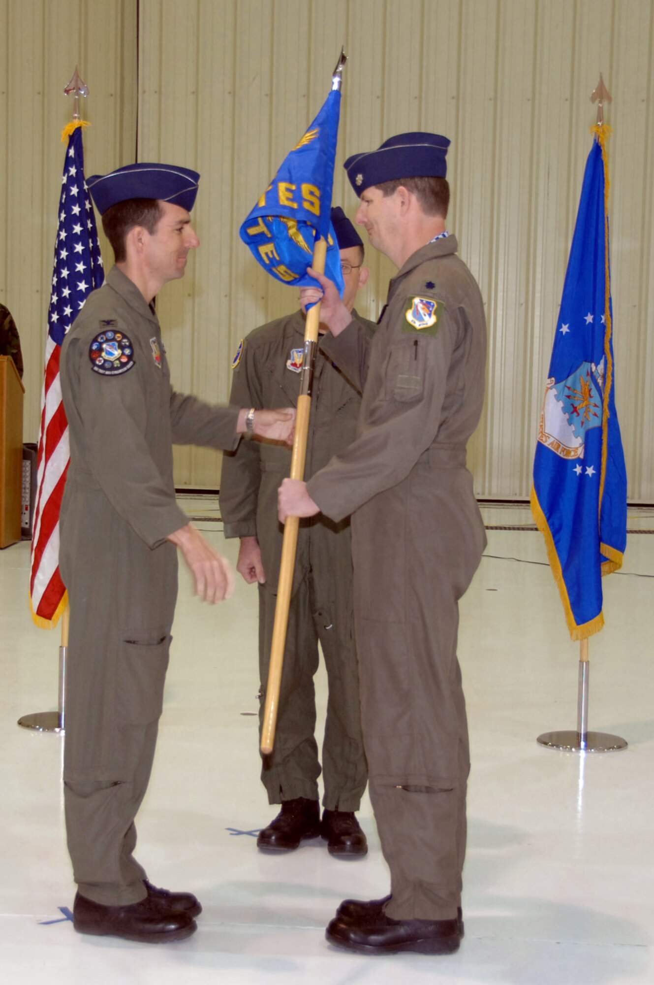 Col. Brian O' Rear hands off the guideon to Lt. Col. Ty Moyers during a squadron activation ceremony for the 53rd Test and Evaluation Group March 5 at Chreech Air Force Base, Nev. Colonel O'Rear is the 53rd TEG deputy commander. Colonel Moyers is the new 556th Test and Evaluation Squadron commander. (U.S. Air Force photo/Staff Sgt. Scottie McCord) 