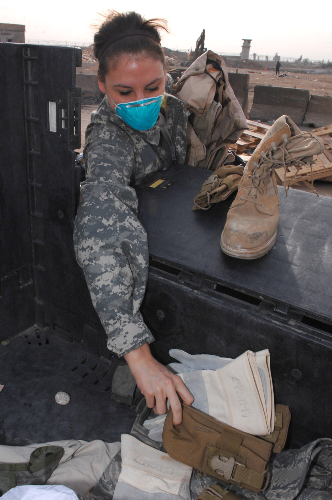 Senior Airman Frances Gavalis gathers up unserviceable uniform items to burn March 10 at Balad Air Base, Iraq. Any servicemember or Department of Defense civilian can drop off items for destruction. Airman Gavalis, a 332nd Expeditionary Logistics Readiness Squadron equipment manager, is deployed from Kirtland Air Force Base, N.M. (U.S. Air Force photo/Senior Airman Julianne Showalter) 
