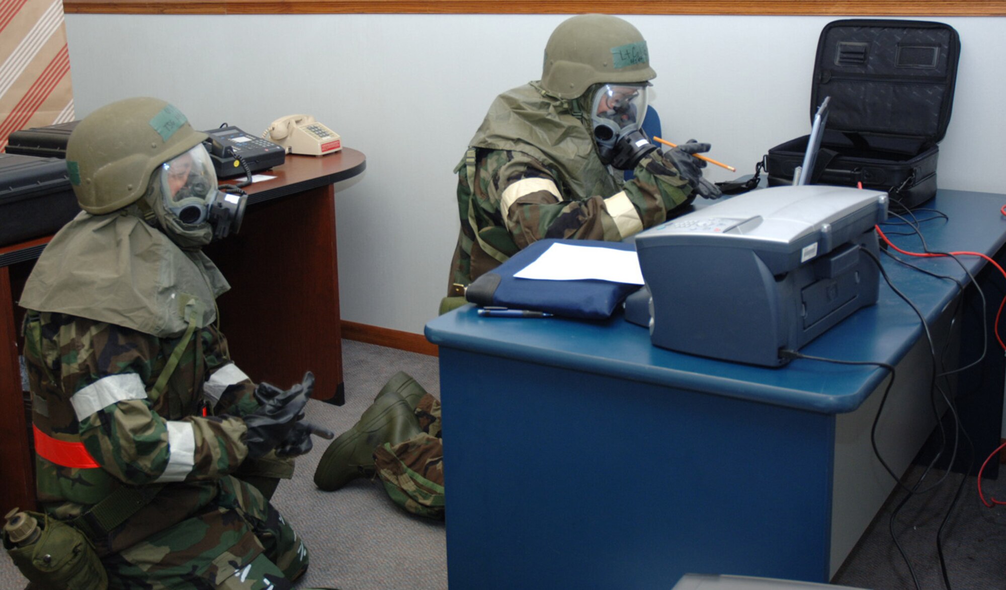 Tech Sgt. Crystal Maxton watches Lt. Col. William Eaton use a pencil to type while wearing protective gloves and providing intelligence support for a training exercise at McConnell Air Force Base, Kan., in early March. Their unit, the 931st Intelligence Directorate, was recently named Air Mobility Command Outstanding Air Reserve Component Intelligence Unit of the Year for 2007. (U.S. Air Force photo/Senior Airman Connor Burkhard)