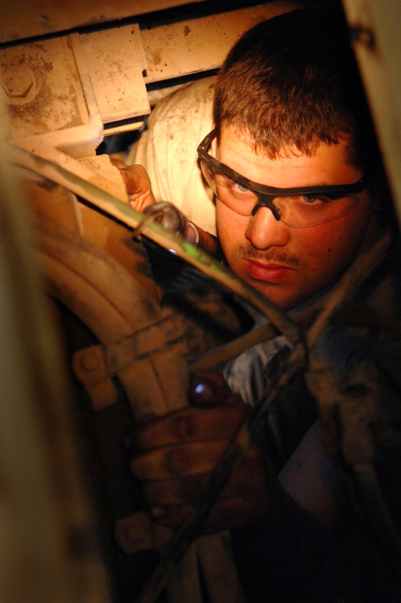Staff Sgt. Alex Blackburn examines a refueling truck's torque converter after replacing broken bolts on the fly wheel March 8 at Balad Air Base, Iraq. The fly wheel is an integral part of the engine that starts the refueling truck. Keeping the more than 20-year-old trucks operational is a vital part of Sergeant Blackburn's work. Without the work of the mechanics such as the sergeant, aircraft, base generators and many other types of equipment would be left bone dry. Sergeant Blackburn, a 332nd Expeditionary Logistics Readiness Squadron refueling truck mechanic, is deployed from F.E. Warren Air Force Base, Wyo. (U.S. Air Force photo/Senior Airman Julianne Showalter) 
