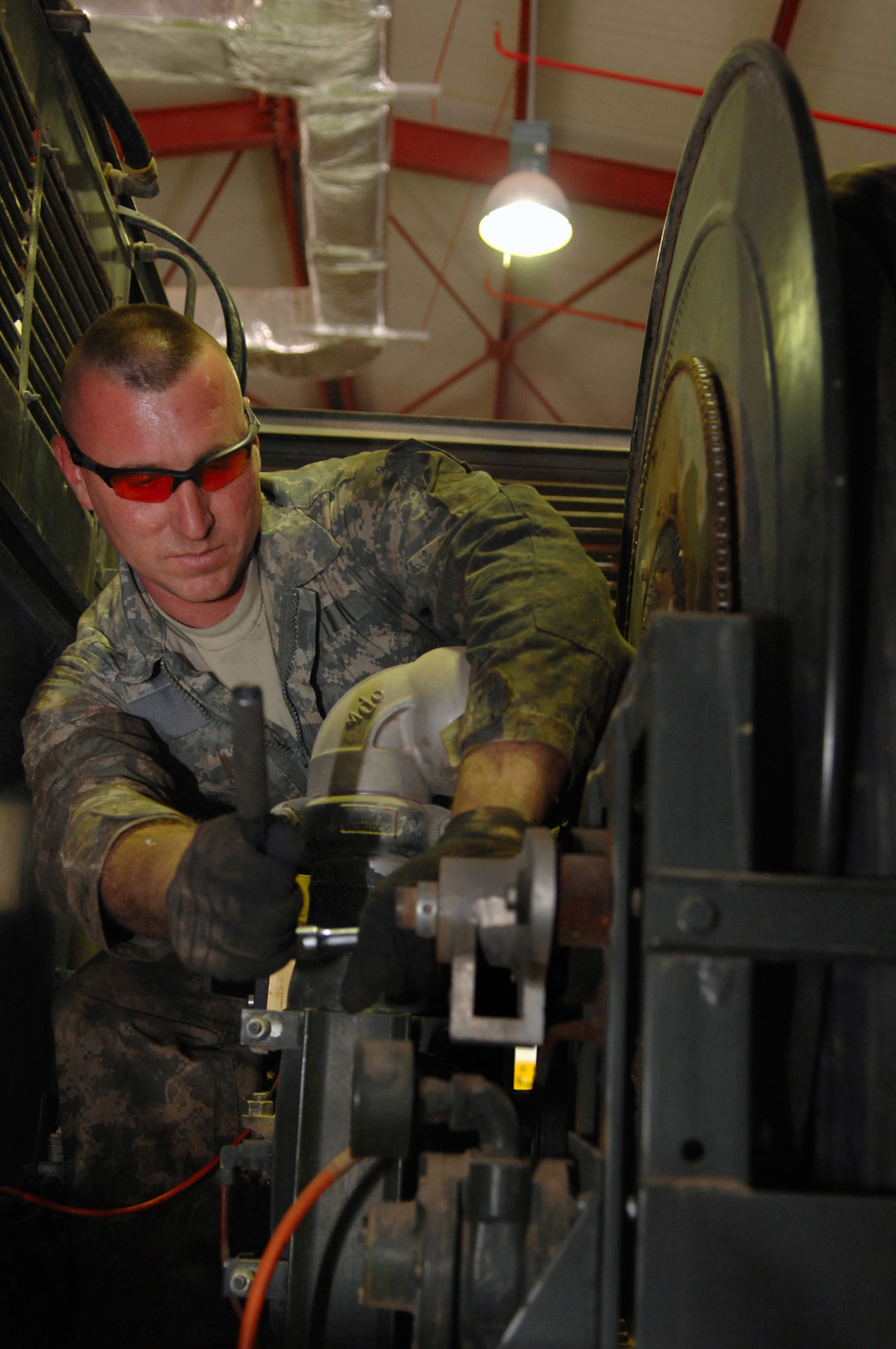 Staff Sgt. Jason Jablonowski tightens the nose reel swivel on a refueling truck that allows the refueling line to roll out of the truck smoothly to aircraft waiting to be refueled March 8 at Balad Air Base, Iraq. Sergeant Jablonowski, a 332nd Expeditionary Logistics Readiness Squadron refueling truck mechanic, is deployed from Luke Air Force Base, Ariz. (U.S. Air Force photo/Senior Airman Julianne Showalter) 

