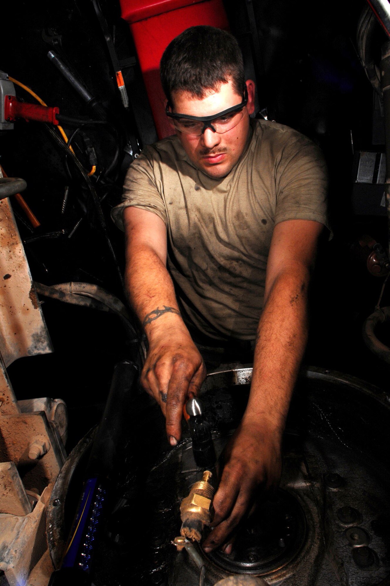 Staff Sgt. Alex Blackburn extracts broken bolts from a fly wheel March 8 at Balad Air Base, Iraq. A fly wheel performs the task of starting the 8.2 liter engine on a refueling truck. Sergeant Blackburn, a 332nd Expeditionary Logistics Readiness Squadron refueling truck mechanic, is deployed from F.E. Warren Air Force Base, Wyo. (U.S. Air Force photo/Senior Airman Julianne Showalter) 
