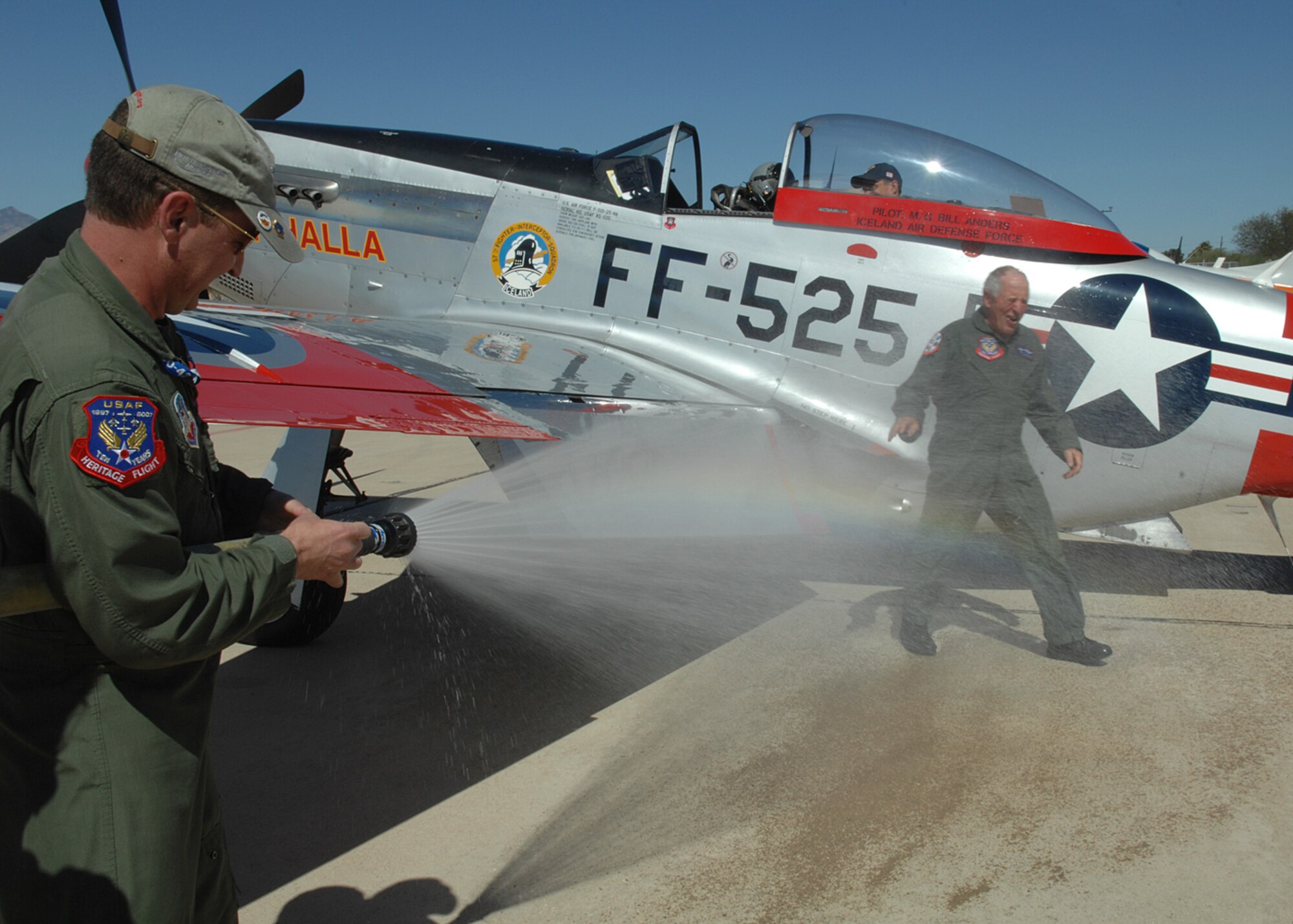 Greg Anders sprays his father, Maj. Gen. (Ret.) Bill Anders with the fire hose after completing his last flying mission in a P-51 Mustang during the Heritage Conference at Davis-Monthan Air Force Base, Arizona on March 7, 2008. General Anders was at D-M to make the conference his last flying experience.  With tradition after a pilot has finished their flying status a person sprays them with a fire hose and their career is honored.  MG Anders was an astronaut on Apollo 8 which was the first person to have left Earth orbit and traveled the moon.  Also, MG Anders is the President for the Heritage Flight Museum.  The conference is held at D-M every March to train new and old pilots and their teams for the up coming air show season.   (US Air Force photo by Senior Airman Jacqueline Hawkins)
