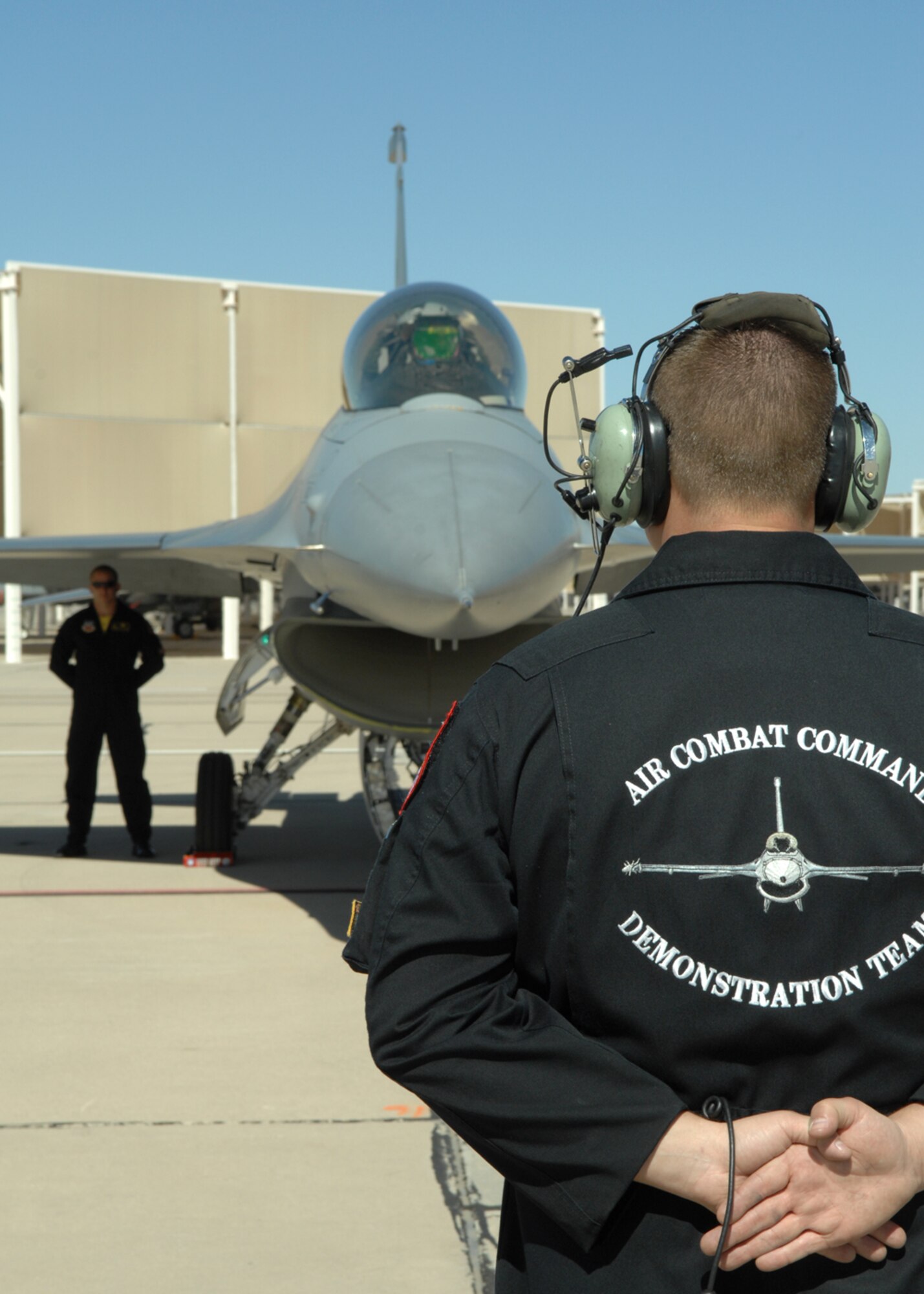Staff Sgt. Ryan L. Douglass prepares to marshal Capt. Julio Rodriguez, F-16 pilot, as he prepares to taxi March 7, at Davis-Monthan AFB, Ariz during the 2008 Heritage Flight Conference. SSgt Douglass is the lead crew chief of the Air Combat Command's "Viper West" F-16 Demonstration Team assigned to the 388th Fighter Wing, Hill Air Force Base, Utah.  The team includes one demo pilot, four pilot safety observers, and nine maintenance personnel. (U.S. Air Force photo/Senior Airman Christina D. Kinsey)
