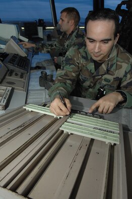 Airman 1st Class Ernesto Rivera,front, tracks flight information of one of the flights on landing roll, while Staff Sgt. Brian Fenton calls the aircraft landing time to base operations March 5 here. Airman Rivera and Sergeant Fenton are both air traffic controllers assigned to the 355th Operations Support Squadron. (U.S. Air Force photo/Senior Airman Christina D. Kinsey)