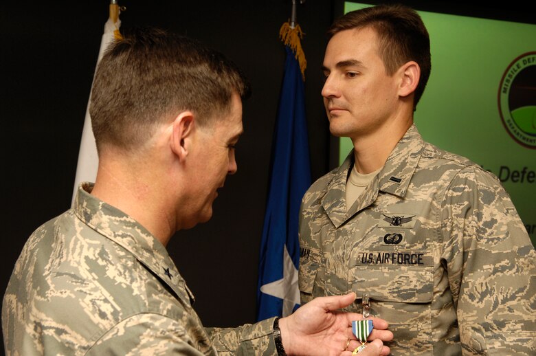 VANDENBERG AIR FORCE BASE, Calif. -- Brig. Gen. Gary Connor presents 1st Lt. Derek Gilman, a Launch Mission Manager from the 1st Air and Space Test Squadron, with the Joint Service Commendation Medal on March 7 for his work on the Missile Defense Agency FTG-03a mission back in September 2007. General Connor is the MDA Ground-Based Mid-course Defense Joint Program Office program director. During the mission a Strategic Targets System rocket was launched from the Kodiak Launch Complex on Kodiak Island, Alaska and was successfully intercepted by the Ground-based Interceptor launched from a launch facility at Vandenberg. The test was the second successful intercept out of Vandenberg. The mission proved once again that the United States has a legitimate deterrent to rogue nation ICBM threats. (U.S. Air Force photo/Airman 1st Class Christian Thomas)