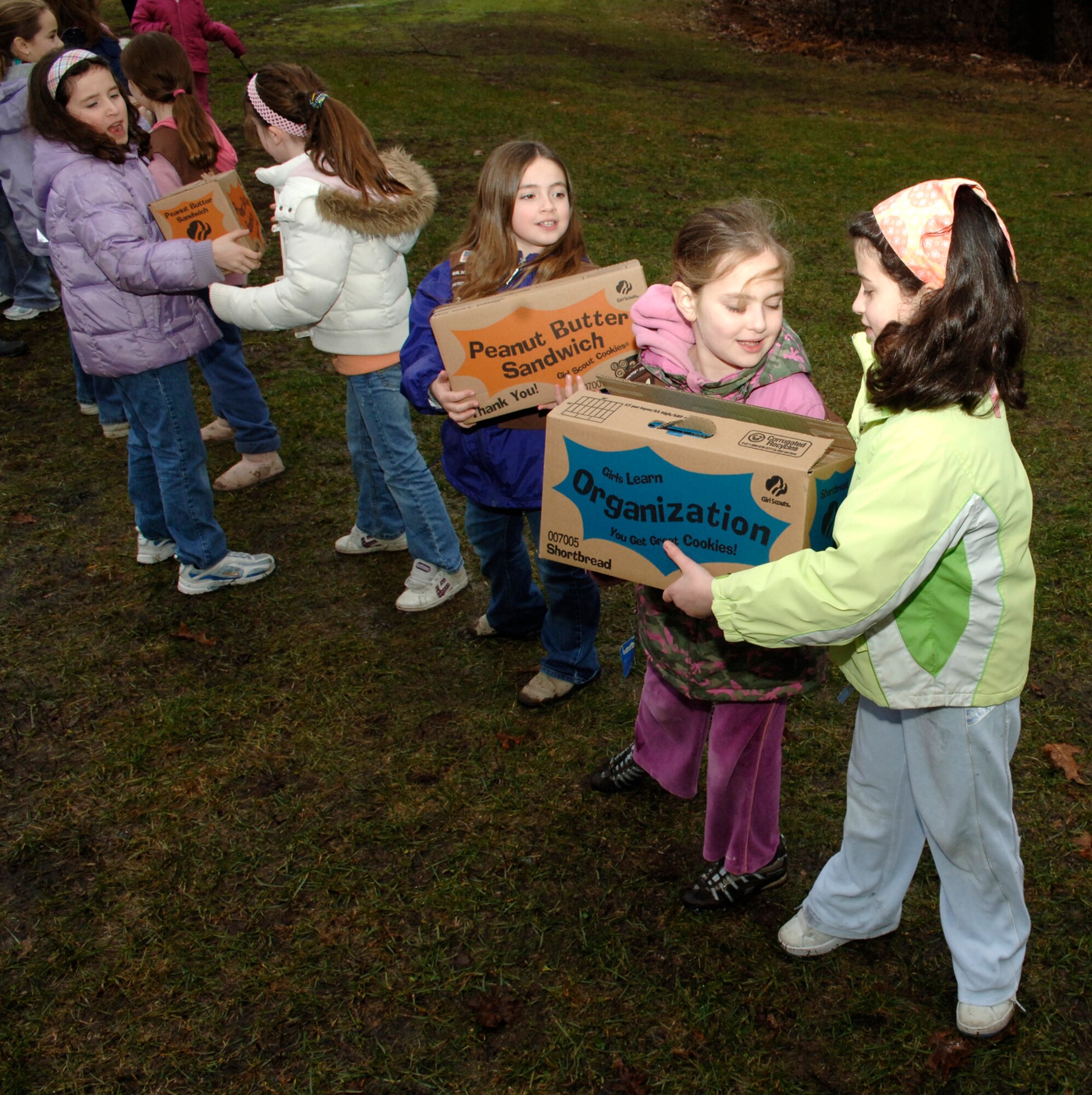 HANSCOM AFB, Mass. – Girl Scouts from across Eastern Massachusetts form a line to help make quick work of off-loading more than 10,000 boxes of Girl Scout cookies that were donated to Hanscom’s Troop Care Package Drive on March 8. Col. Tom Schluckebier, 66th Air Base Wing commander, hosted the event at the tennis bubble for more than 400 scouts and their families. The girls had the opportunity to meet with many Hanscom Airmen who came out to thank them for their efforts and talk to the scouts about their deployment experiences. (U.S. Air Force photo by Walter Santos)

