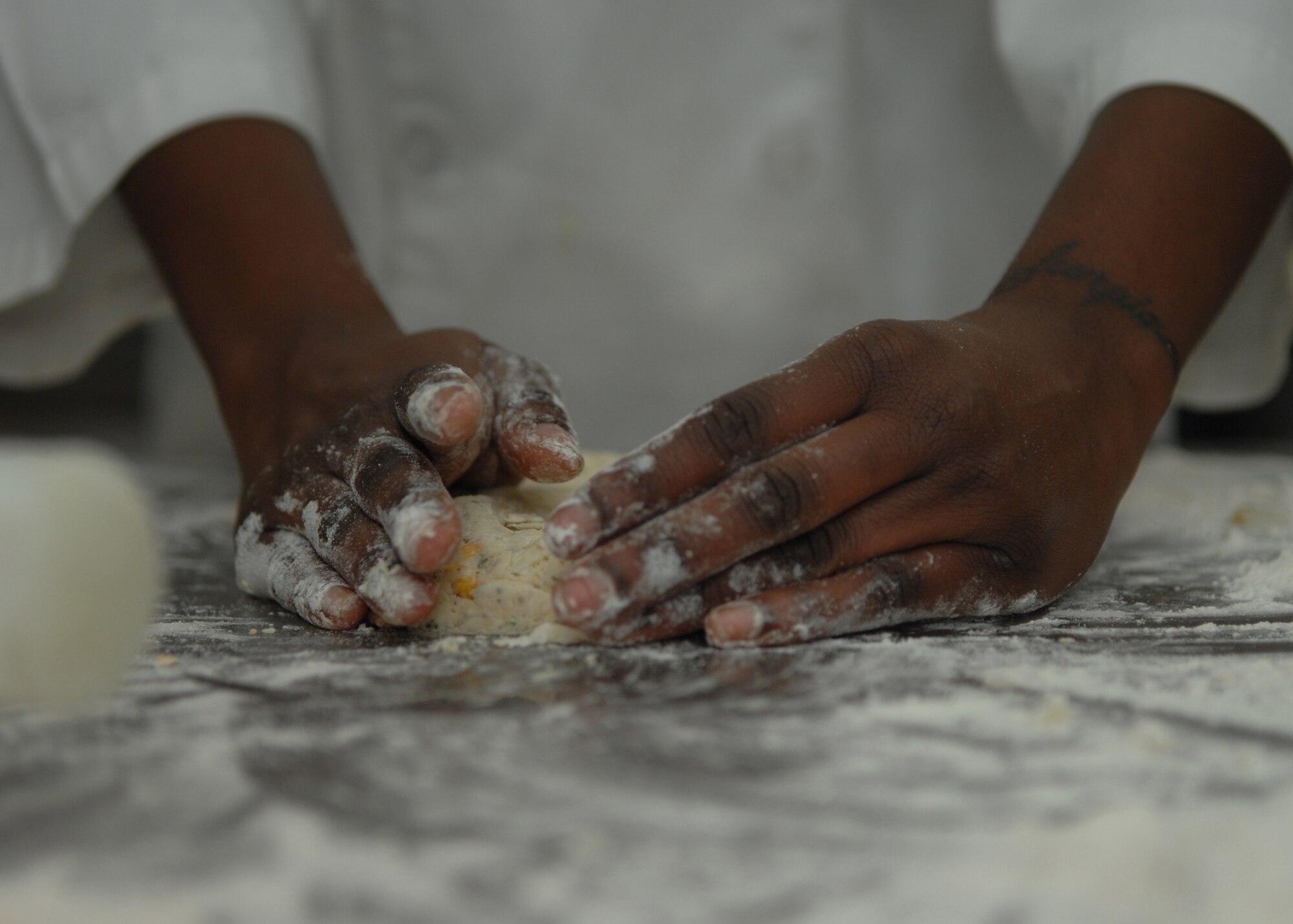 DYESS AIR FORCE BASE, Texas -- Airman 1st Class Britney Robinson, 7th Services Squadron, makes cheese biscuits as part of March 10 lunch menu. (U.S. Air Force photo by Airman 1st Class Jennifer Romig)