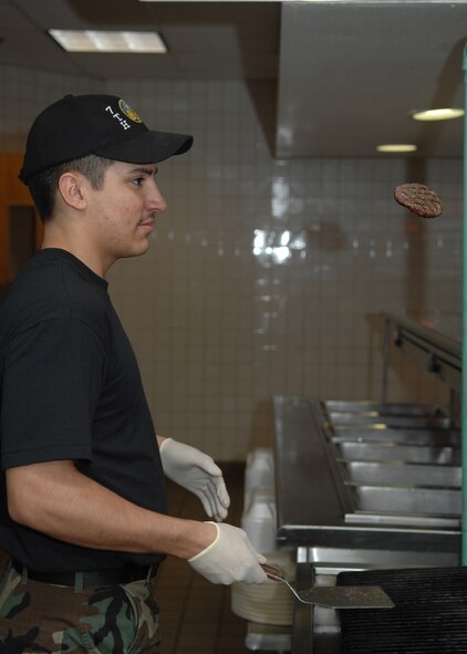 DYESS AIR FORCE BASE, Texas -- Airman 1st Class Joshua Alvarez, 7th Services Squadron, grills burgers as part of the March 10 lunch menu. (U.S. Air Force photo by Airman 1st Class Jennifer Romig)