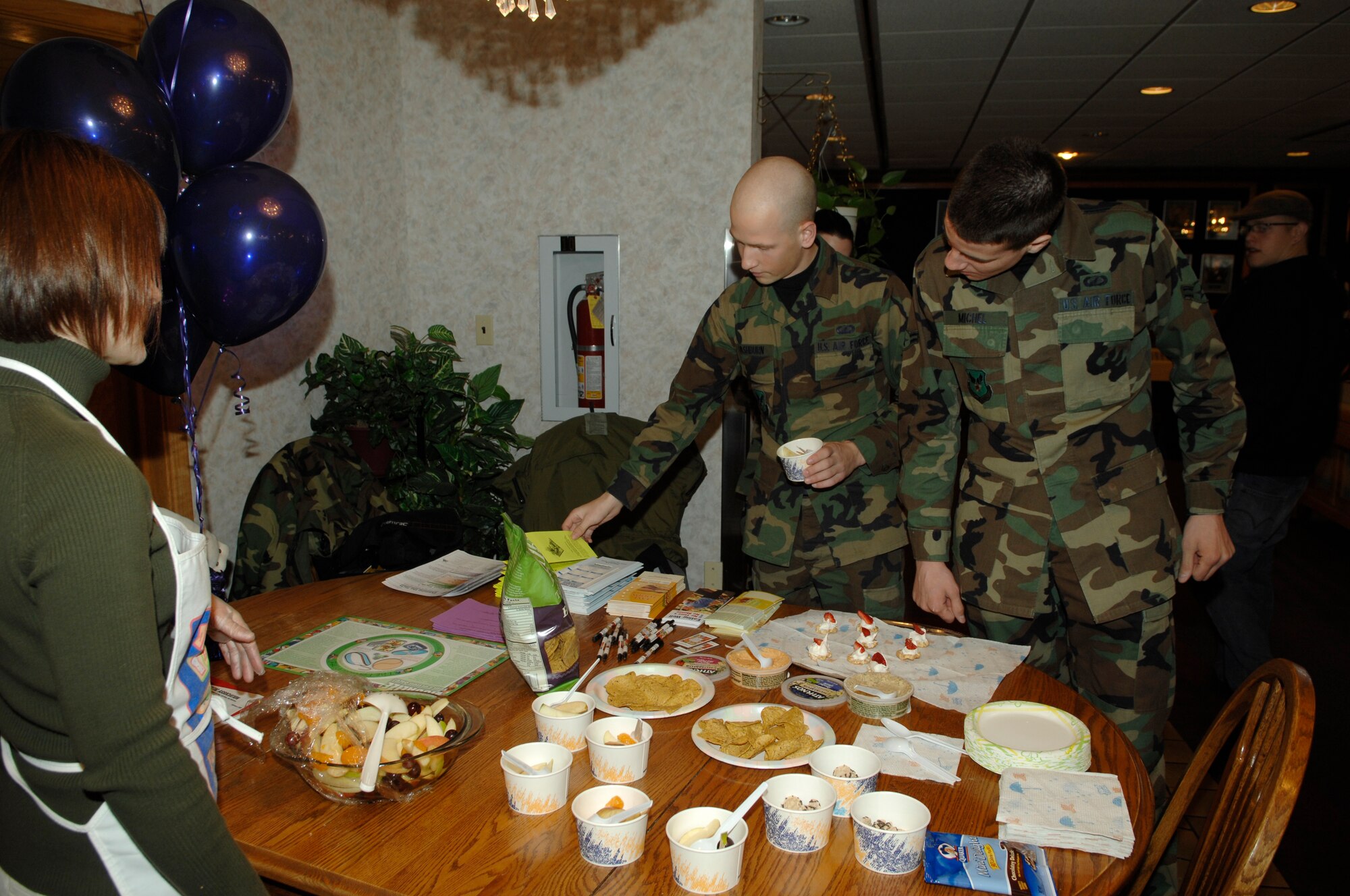 Center, Airmen 1st Class Alex Washburn and Chris Michel, Air Force Financial Services Center, examine various nutritional pamphlets on display for National Nutrition Month as Kathi Murray, 28th Medical Operations Squadron, answers questions. The pamphlets, in additional to a wide variety of healthy snacking alternatives, were part of a demonstration March 7 at the Bandit Inn. (U.S. Air Force by Airman 1st Class Kasey Zickmund)
