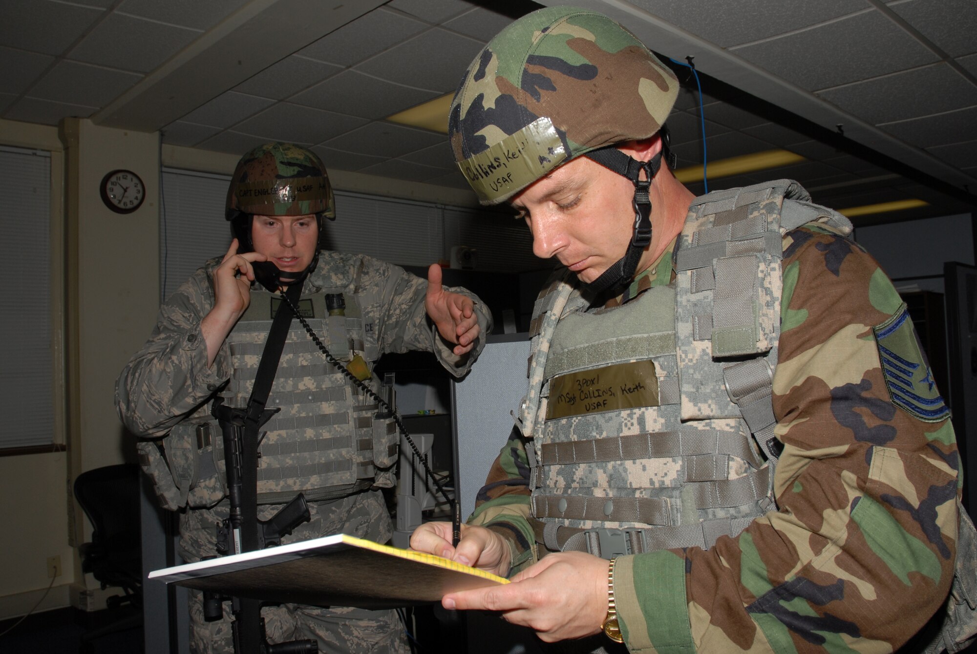 Capt. William Englebert, relays pertinent information to the law enforcement desk that Master Sgt. Keith Collins has received from the perpetrator of a hostile situation scenario at the 18th Comptroller Squadron building, during the 2008 Pacific Air Forces Operational Readiness Inspection at Kadena Air Base, Japan, March 11, 2008. PACAF is conducting the inspection from March 9 to 15 to validate the mission readiness of the 18th Wing. Both Captain Englebert and Sergeant Collins are from the 18th Security Forces Squadron. (U.S. Air Force photo/Staff Sgt. Chrissy FitzGerald)