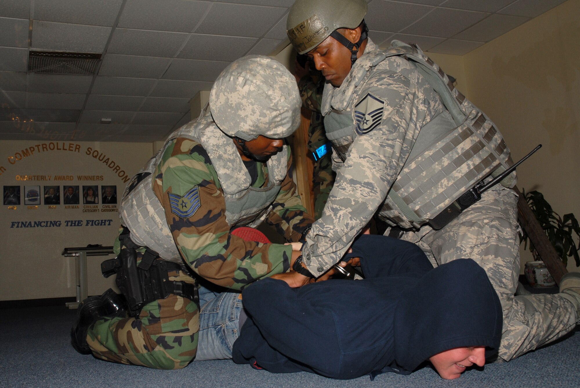 Master Sgt. Anthony Johnson and Tech. Sgt. Costello Williams, both assigned to the 18th Security Forces Squadron, take down and handcuff a perpetrator during a hostile situation scenario at the 18th Comptroller Squadron building, during the 2008 Pacific Air Forces Operational Readiness Inspection at Kadena Air Base, Japan, March 11, 2008. PACAF is conducting the inspection from March 9 to 15 to validate the mission readiness of the 18th Wing. (U.S. Air Force photo/Staff Sgt. Chrissy FitzGerald)