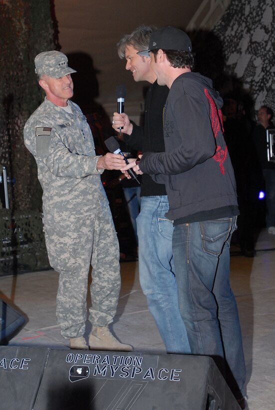U.S. Army Lt. Gen. James J. Lovelace, left, commanding general of U.S. Central Army and Combined Forces Component Command, presents his commander's coin to MySpace co-founders Chris DeWolfe, center, and Tom Anderson, right, on March 10, 2008. The social networking Web site presented a concert for the troops at Camp Buehring, Kuwait. 