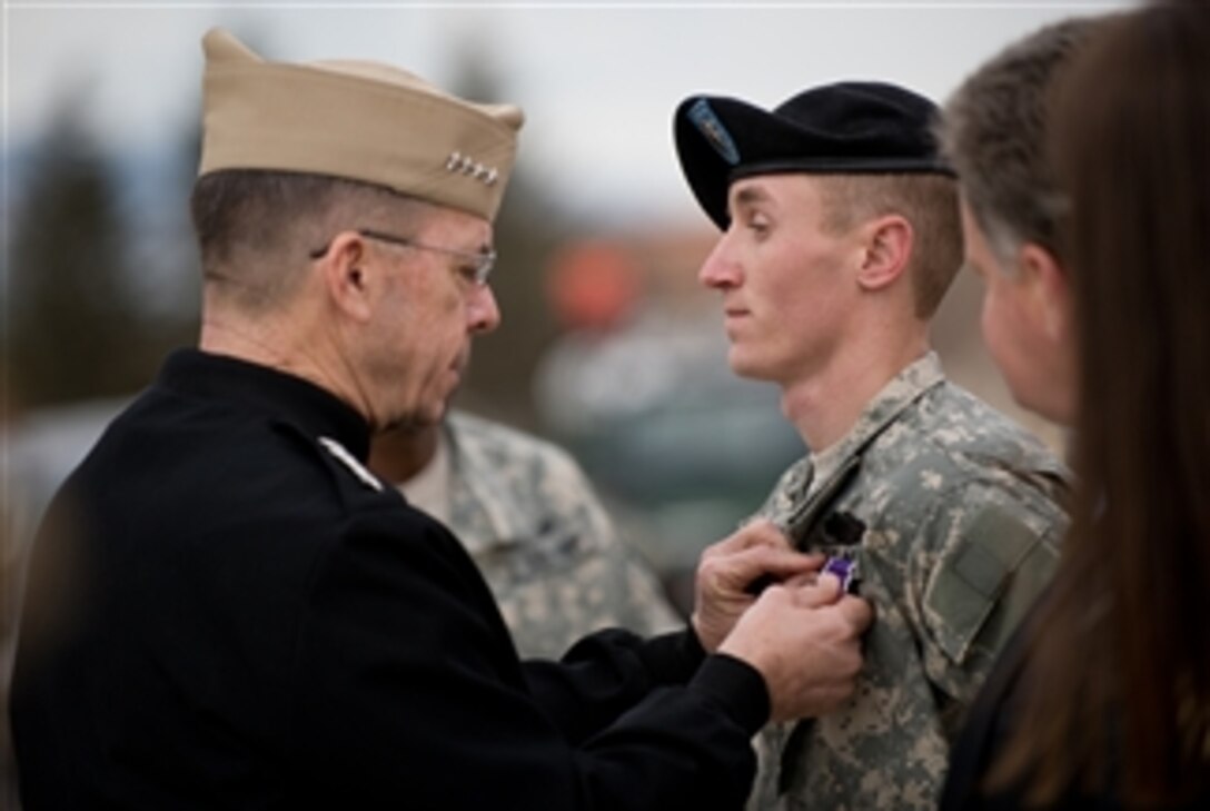 U.S. Navy Adm. Mike Mullen, chairman of the Joint Chiefs of Staff, presents the Purple Heart to Sgt. Randy Brown, Warrior Transition Battalion, Fort Carson, Colo., March 10, 2008. Brown was injured by an improvised explosive device while on patrol in Iraq in March 2006. While injured, Brown pulled his platoon and team leaders out of their burning Humvees.