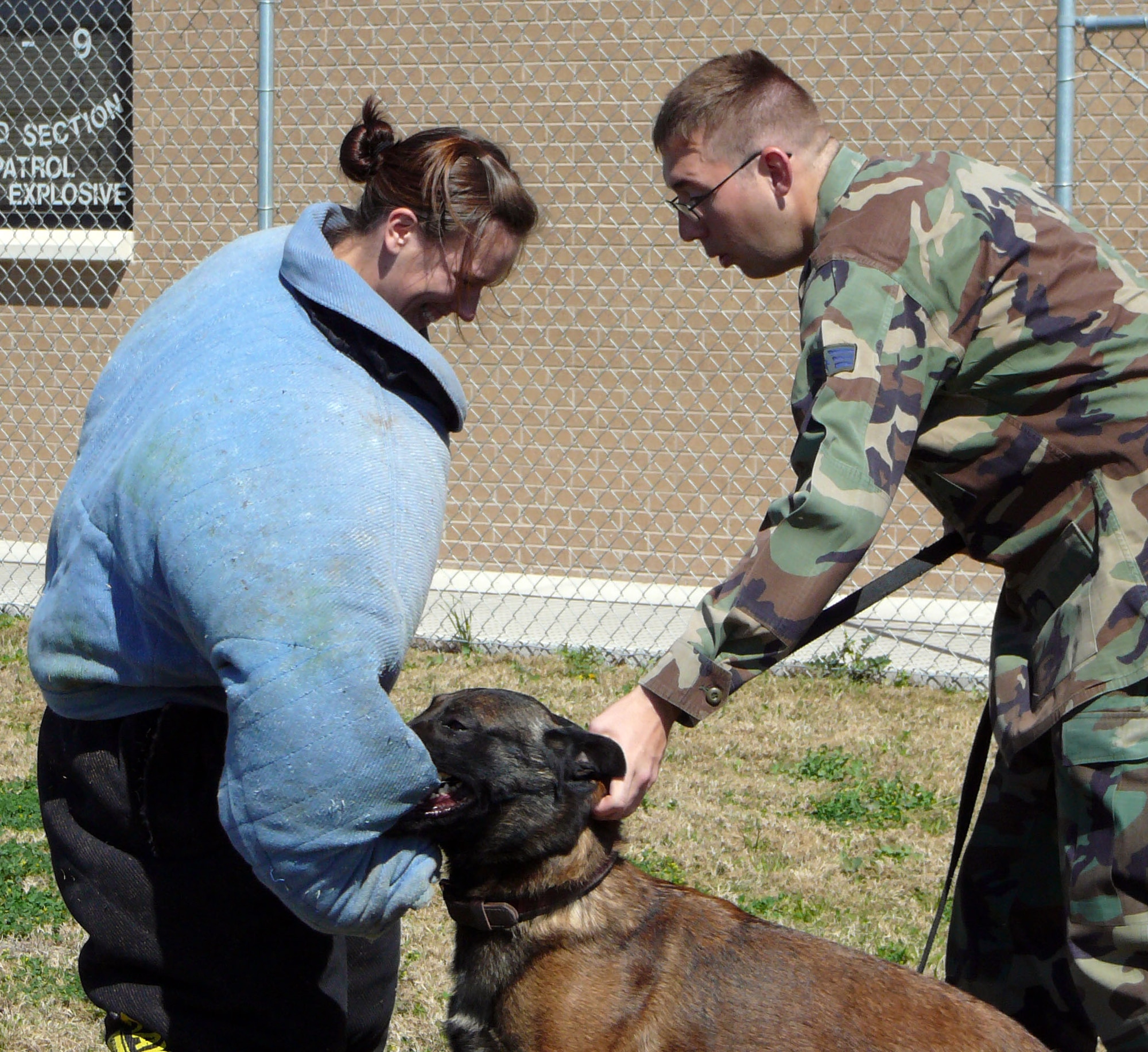 LAUGHLIN AIR FORCE BASE, Texas – Senior Airman Ryan Troester, 47th Security Forces Squadron K-9 Division, coaxes his military working dog Xxavier off the arm of 2nd Lt. Lori Houck, 47th Mission Support Group, during a training demonstration.  (Contributed photo) 