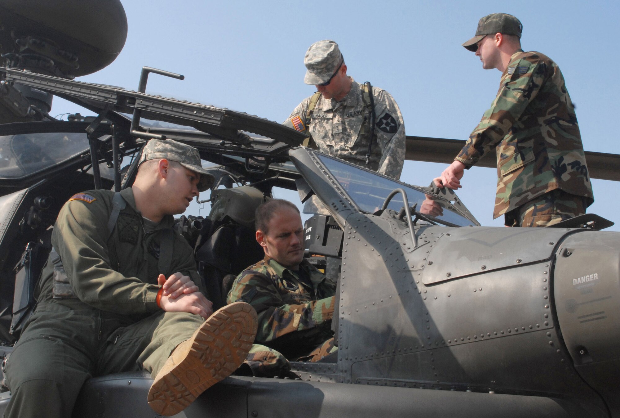 Chief Warrant Officer 2nd Class Thomas Weekley (front left), a pilot with Charlie Company, 42nd Aviation Battalion, from Camp Humphreys, South Korea, discusses the AH64D Apache helicopter with Senior Airman Richard Addis, an electronic warfare craftsman with the 8th Maintenance Squadron at Kunsan Air Base, South Korea, while Chief Warrant Officer 3rd Class Pat Nager (rear left), a standardization instructor pilot with Charlie Company, answers questions about fire rescue operations from Senior Airman Joshua McGinnis, a firefighter with the 8th Civil Engineer Squadron.  Army aviators brought the helicopter to Kunsan March 10 to inform Airmen about the aircraft and the Army's current mission in South Korea.  (U.S. Air Force photo/Staff Sgt. Darcie Ibidapo)