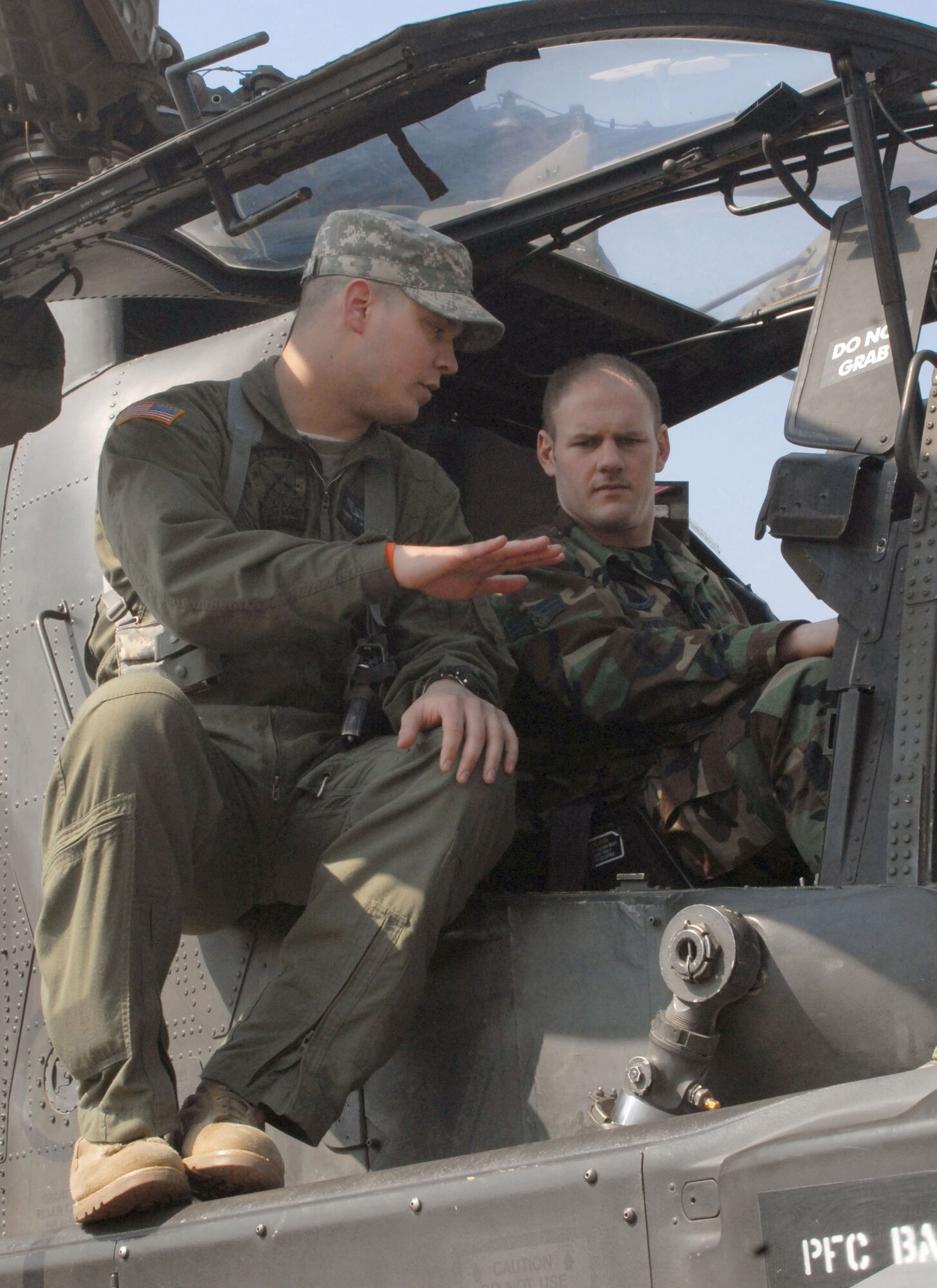 Chief Warrant Officer 2nd Class Thomas Weekley, a pilot with Charlie Company, 42nd Aviation Battalion, from Camp Humphreys, South Korea, discusses the AH64D Apache helicopter with Senior Airman Richard Addis, an electronic warfare craftsman with the 8th Maintenance Squadron at Kunsan Air Base, South Korea, during a static display of the aircraft March 10.  Army aviators brought the helicopter to Kunsan to inform Airmen about the aircraft and the Army's current mission in South Korea.  (U.S. Air Force photo/Staff Sgt. Darcie Ibidapo)
