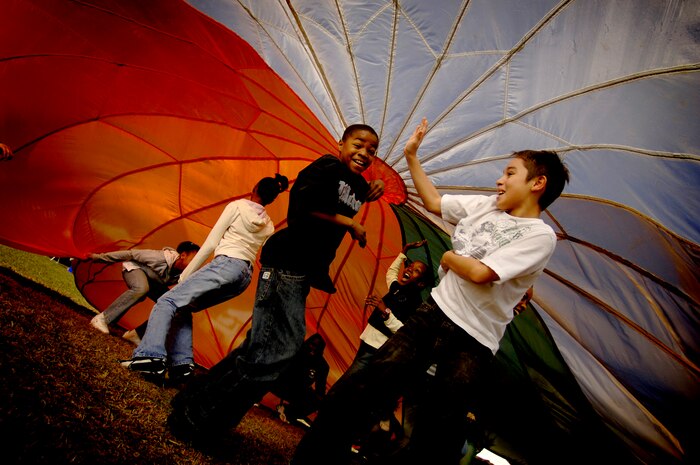 Fifth-graders from Hunley Park Elementary School in North Charleston  play inside of a parachute during the Earth Day celebration on base Wednesday. (U.S. Air Force photo/Senior Airman Nicholas Pilch)