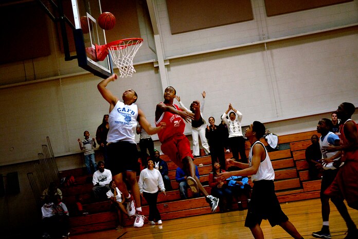 Charles Washington, white jersey, speeds past the defense to score two points during the state championship game at the base gym Saturday. Charles, the 17-year-old son of Master Sgt. Charles Washington, plays on the Charleston AFB Blue youth basketball team. (U.S. Air Force photo/Senior Airman Nicholas Pilch)
