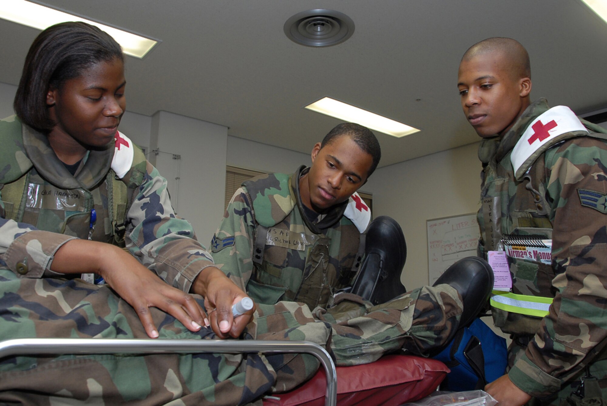 Airman 1st Class Gala Hamilton, 18th Dental Squadron, demonstrates how to use an atropine kit for Airman 1st Class Richard Glass and Senior Airman Justin Rice, both from the 18th Dental Squadron, during the 2008 Pacific Air Forces Operational Readiness Inspection at Kadena Air Base, Japan, March 11, 2008. PACAF is conducting the inspection from March 9 to 15 to validate the mission readiness of the 18th Wing. (U.S. Air Force photo/Staff Sgt. Darnell T. Cannady)

