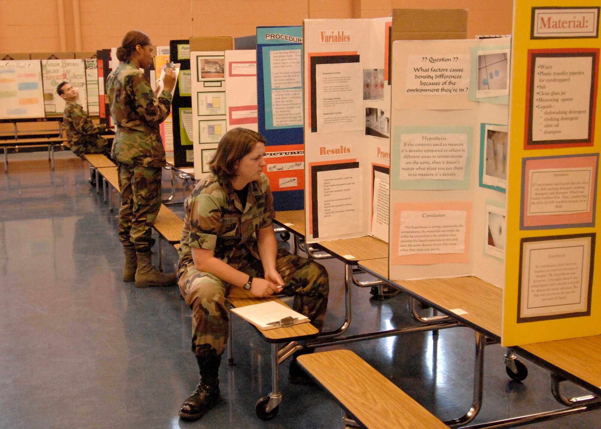 Los Angeles AFB personnel inspect  student science projects at Dana Middle School’s annual science fair, March 5. Approximately 10 people volunteered as judges this year. (Photo by Lou Hernandez)