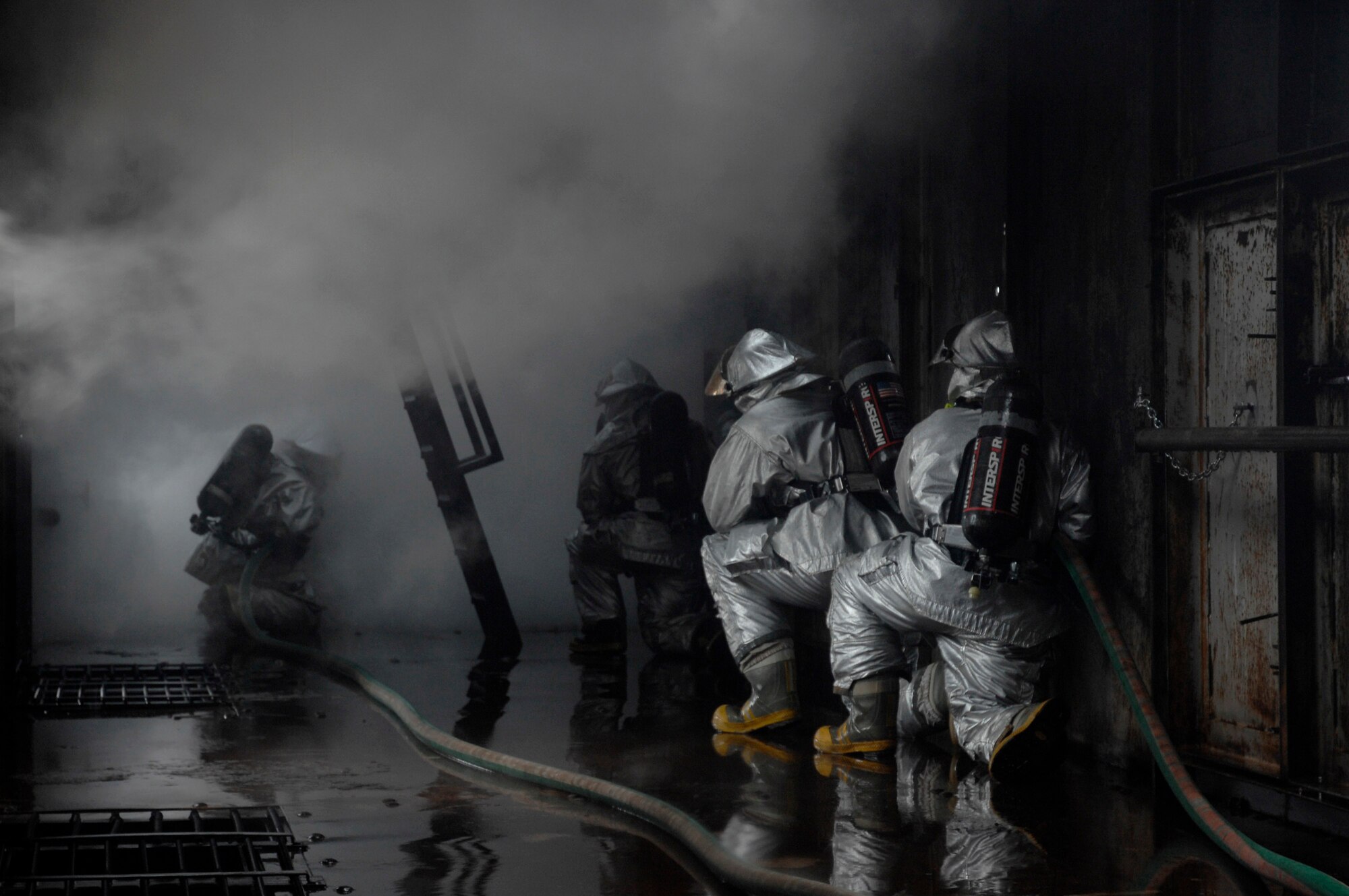 48th Civil Engineer Squadron firefighters are surrounded by steam as they extinguish a simulated cargo fire March 8 at Royal Air Force Mildenhall, England. Firefighters must train constantly to stay proficient in their aircraft rescue and firefighting skills. (U.S. Air Force photo/Airman Perry Aston) 