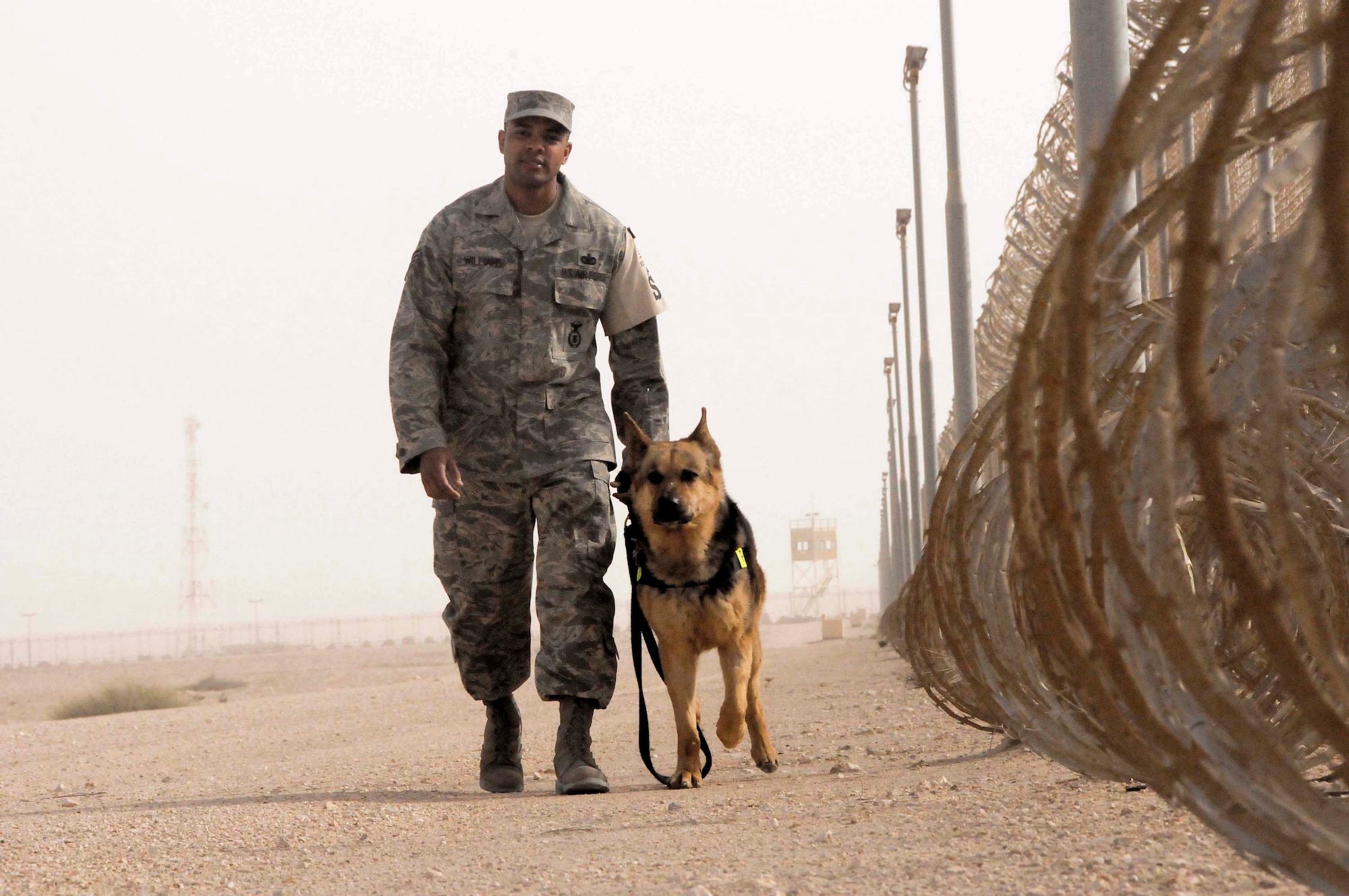 Staff Sgt. Kenneth Williams walks with Bruno, a military working dog, during a perimeter check March 4 in Southwest Asai. Sergeant Williams is a member of the 379th Expeditionary Security Forces Squadron. (U.S. Air Force photo/Senior Airman Domonique Simmons) 
