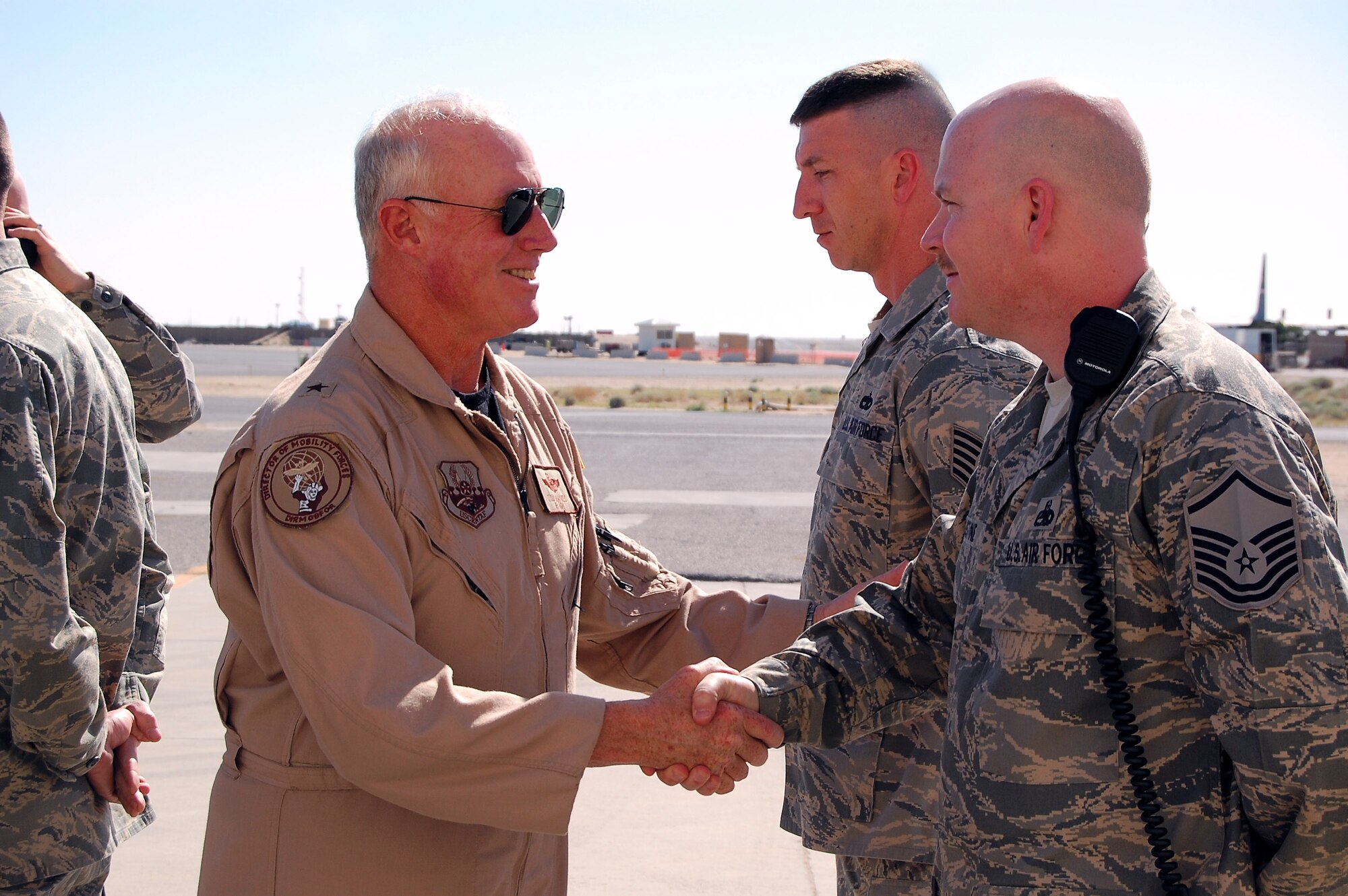 Brig. Gen. Thomas Haynes shakes hands with Master Sgt. Henry Augustine while Tech. Sgt. Michael Edie stands in the background during the general's March 8 visit to a Southwest Asia air base. General Haynes, the U.S. Air Forces Central director of mobility forces, visited the 386th Air Expeditionary Wing to see firsthand how Airmen support the deployed airlift mission. Sergeant Augustine is deployed from MacDill Air Force Base, Fla., and Sergeant Edie is deployed from Yokota Air Base, Japan. (U.S. Air Force photo/Capt. Jason McCree)
